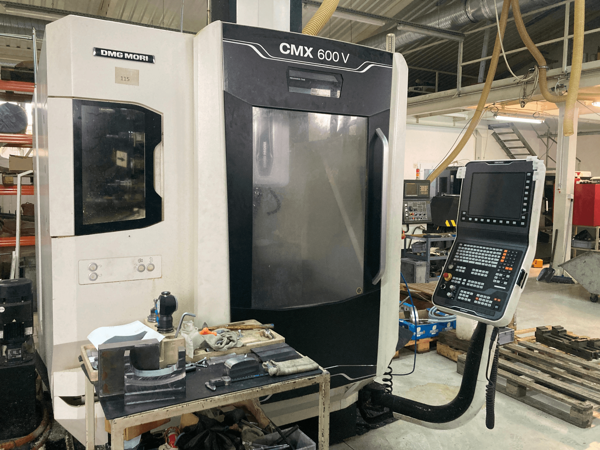 Frézka DMG MORI CMX 600 V při pohledu zepředu, kde je vidět ovládací panel a pracovní stůl s nástroji.