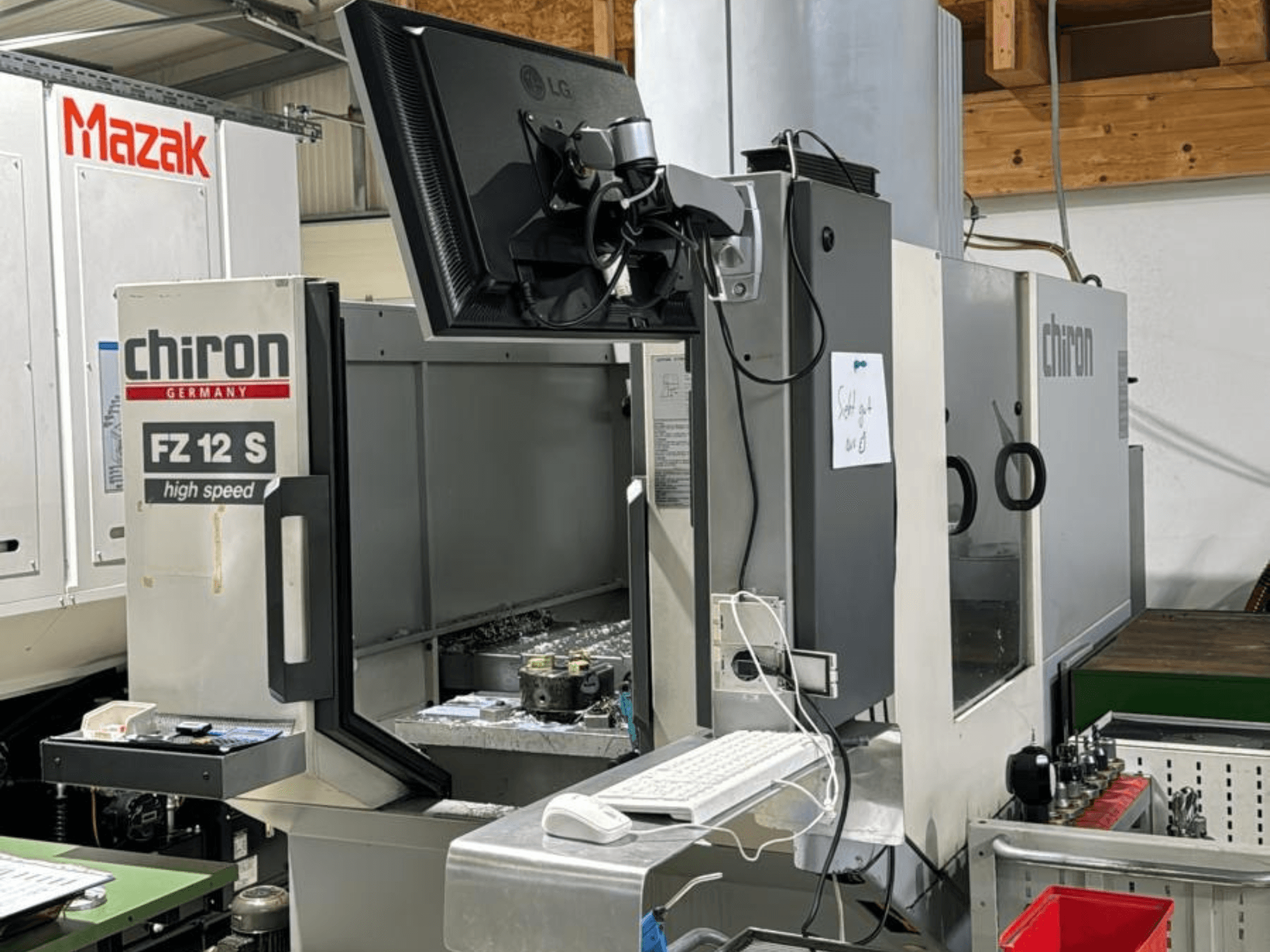 Svislý pohled na vysokorychlostní obráběcí centrum CHIRON FZ 12 S s ovládacím displejem a úlomky z procesu obrábění.