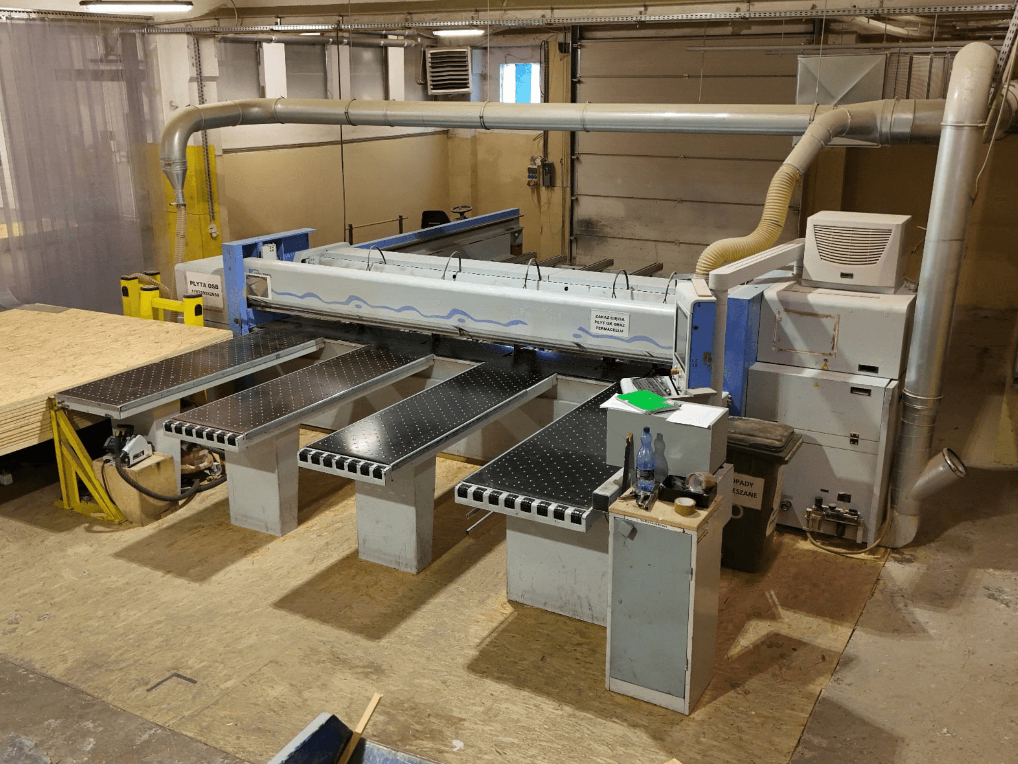 Plošná pila HOLZMA HPP 350/43/38 v dílně, pohled shora, znázorňující řezací plochu a opěrné stoly.