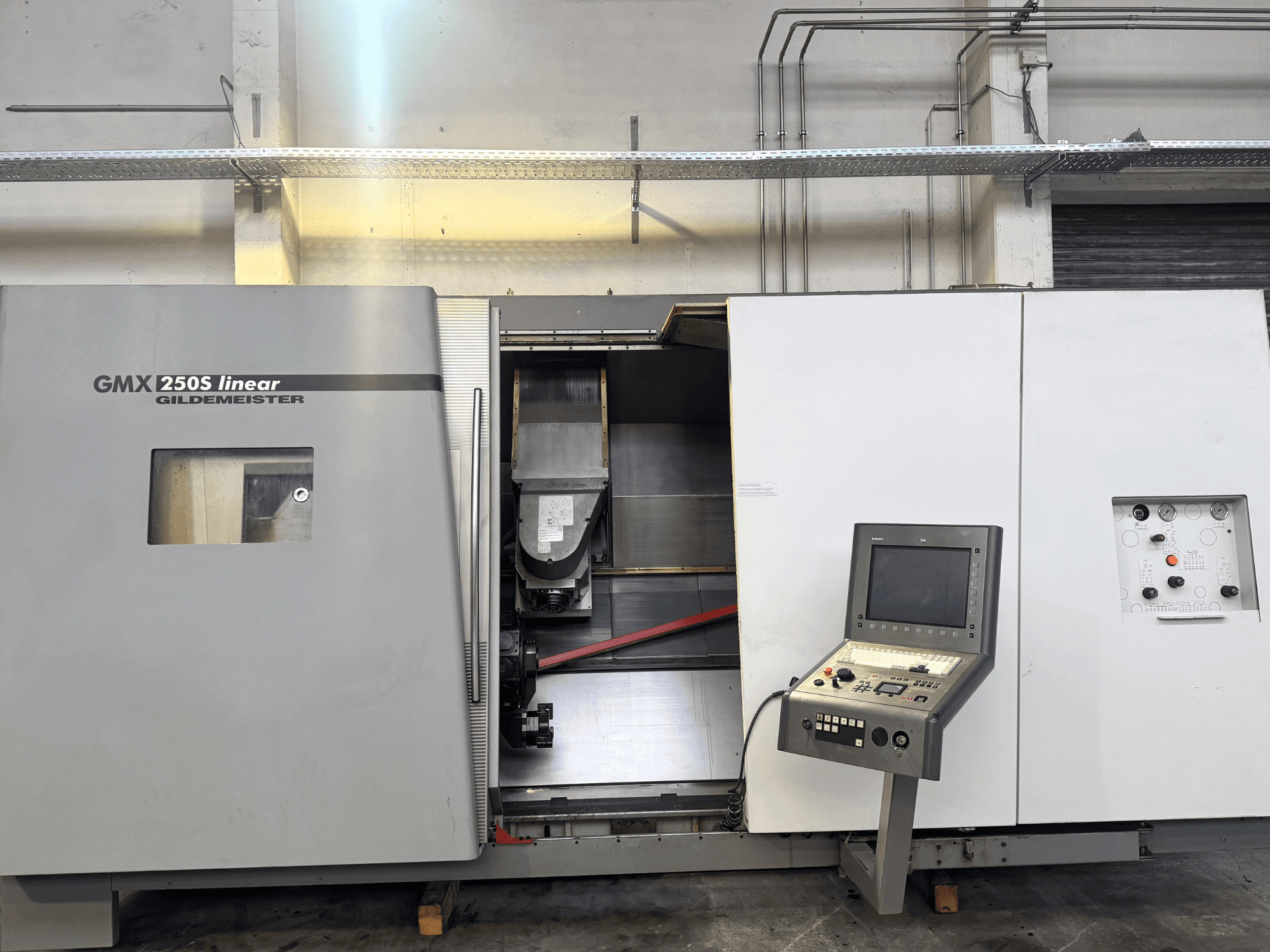 Lineární CNC stroj Gildemeister GMX 250S, pohled zepředu, ovládací panel a otevřený pracovní prostor.