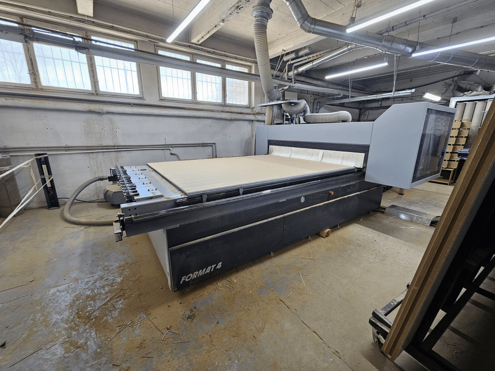 CNC frézka FORMAT4 Profit H80 21.31, boční pohled na velký pracovní stůl a ovládací panel v dílenském prostředí.