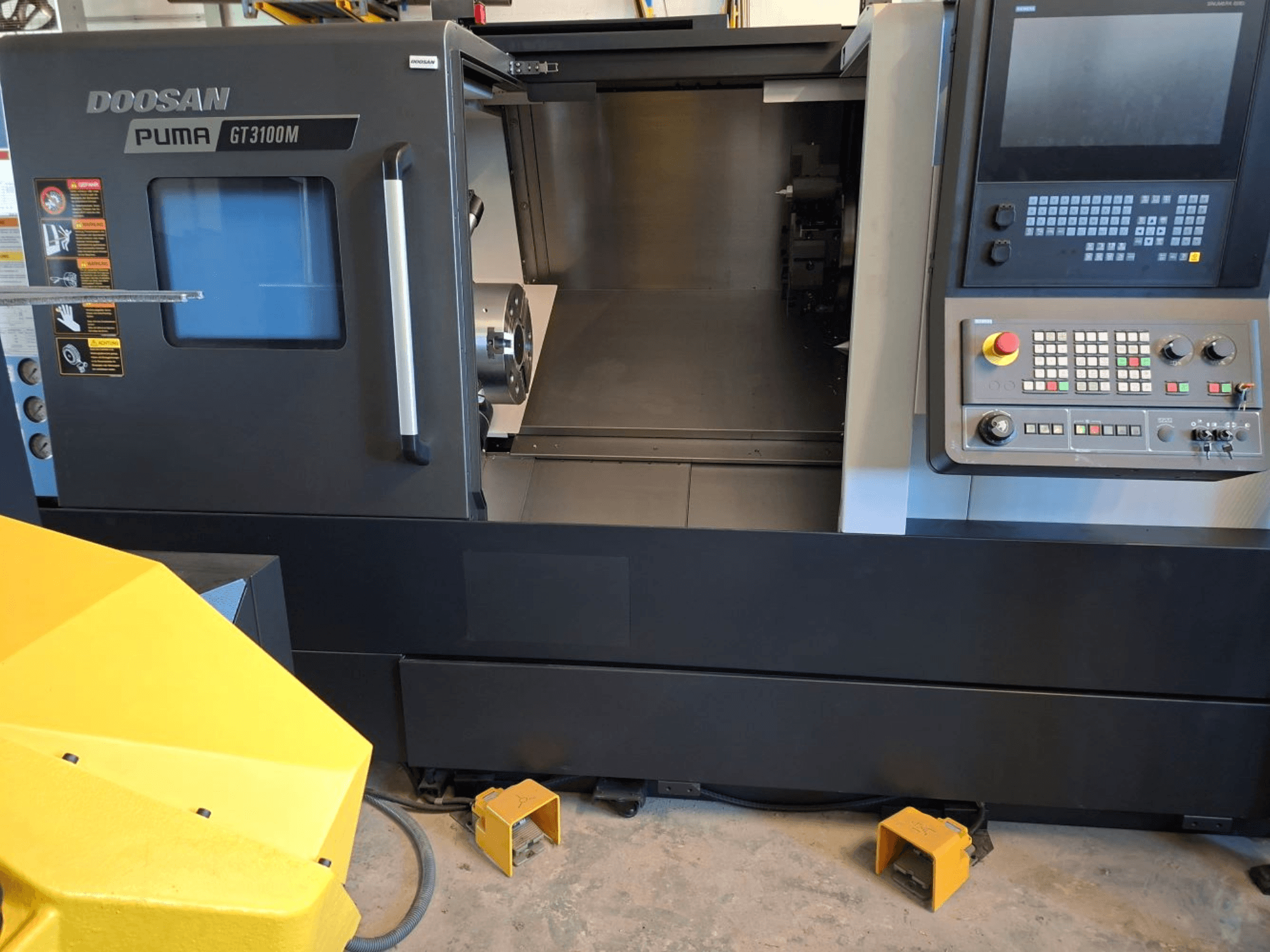 Horizontální soustruh DOOSAN Puma GT 3100 M v čelním pohledu, který ukazuje ovládací panel, otevřenou věž a vnitřní pracovní prostor.