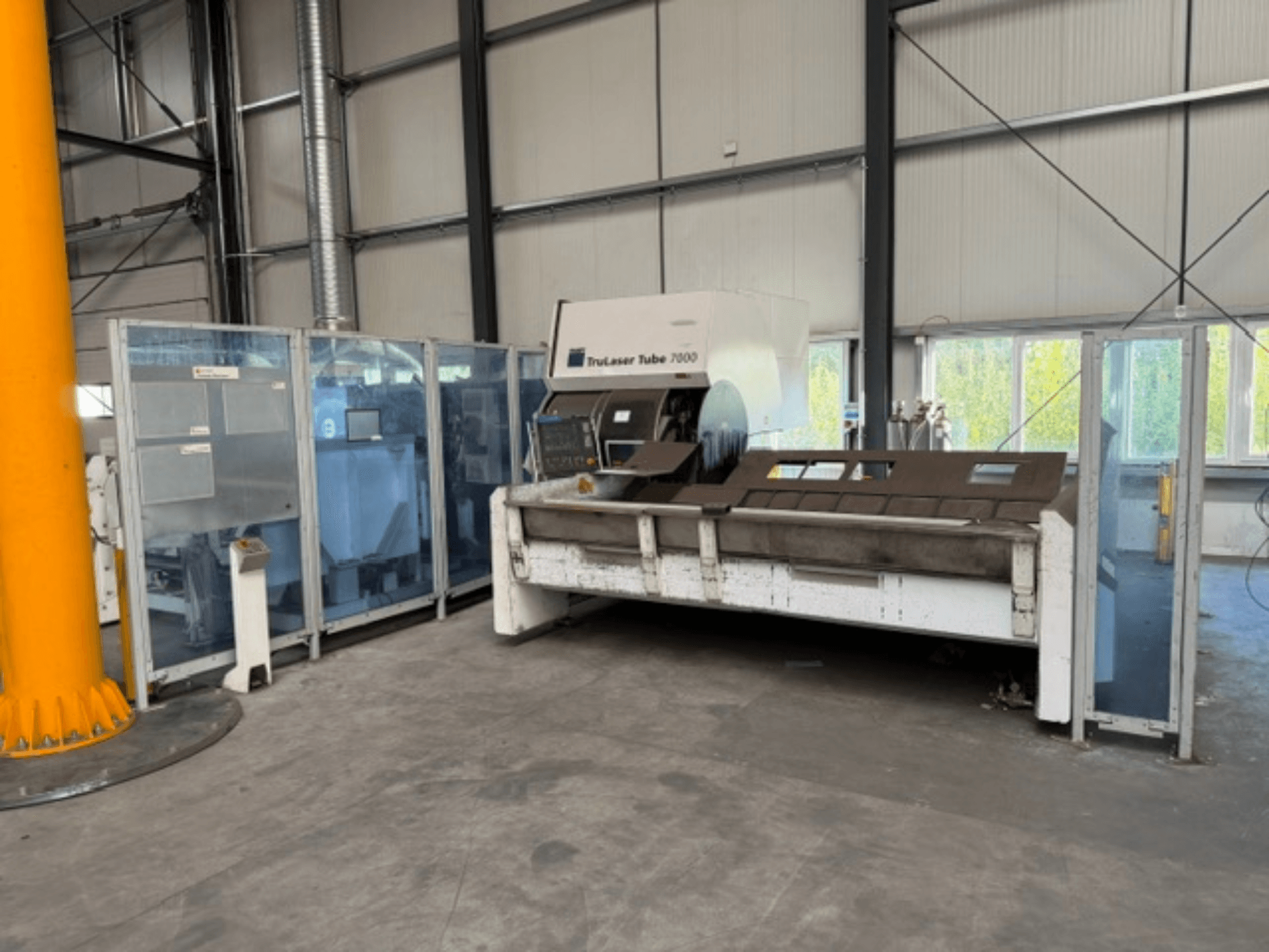 TruLaser Tube 7000 od společnosti TRUMPF, čelní pohled na stroj na řezání trubek v dobře osvětleném průmyslovém prostředí s viditelnými ovládacími prvky.