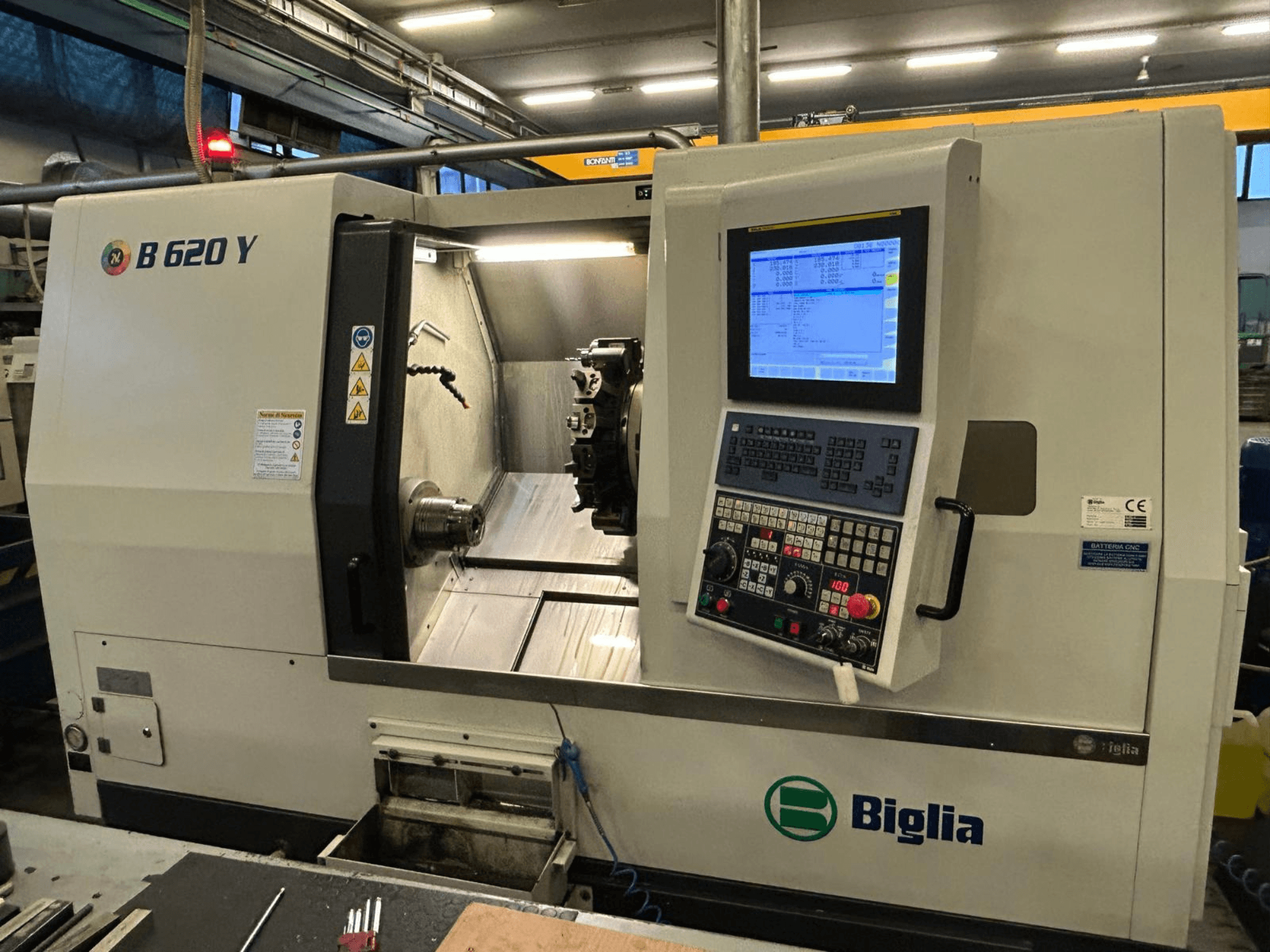 CNC soustruh Biglia B 620 Y v dílně, pohled zepředu, zobrazující ovládací panel s digitálním displejem a obráběcí komponenty.