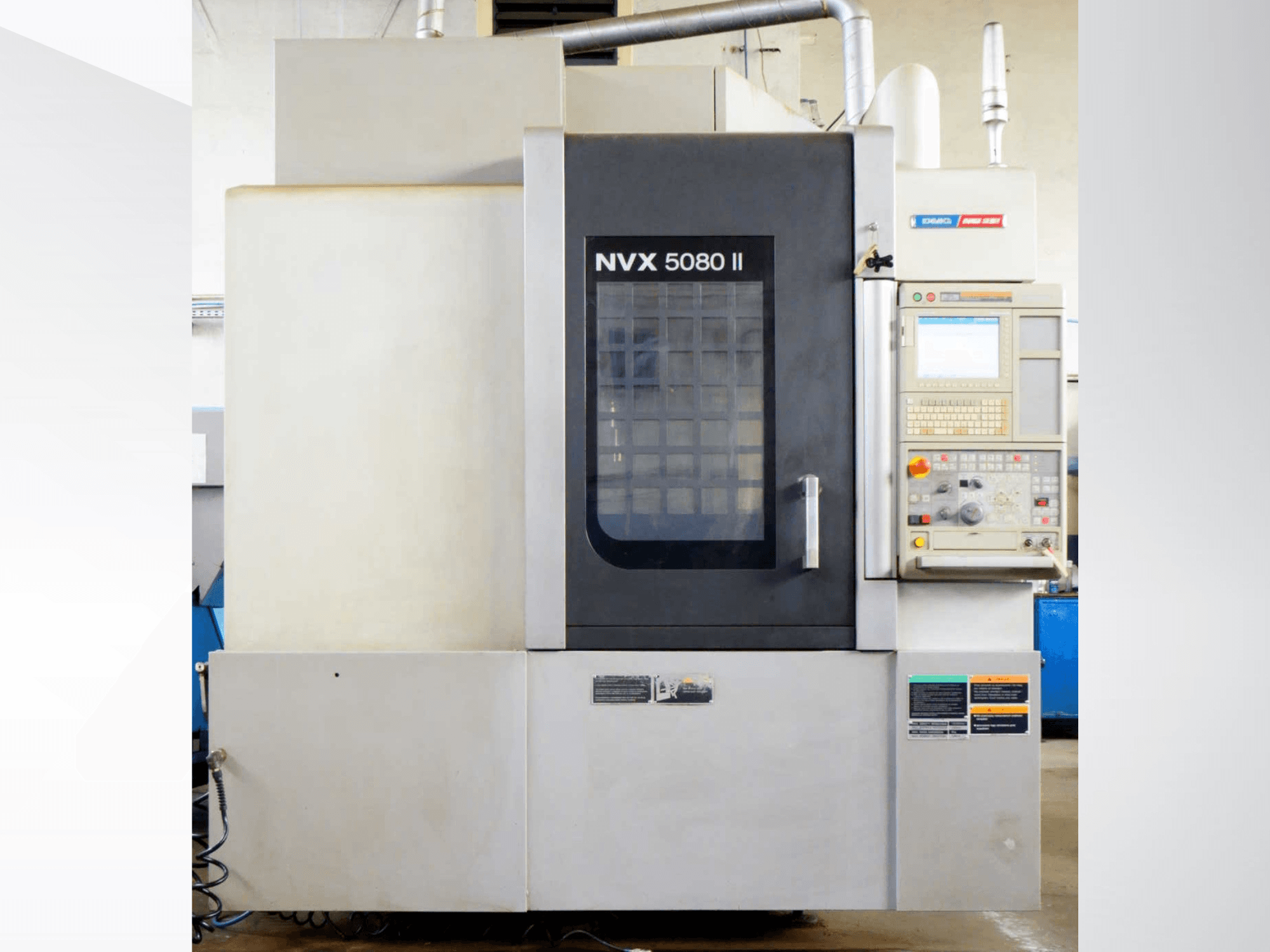 Vertikální obráběcí centrum DMG Mori Seiki NVX 5080 II, pohled zepředu, s ovládacím panelem a mřížkovými dvířky.