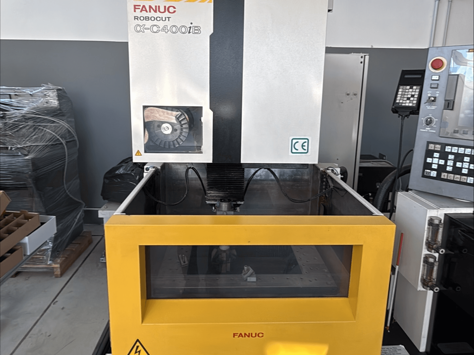Drátový elektroerozivní stroj FANUC Robocut α-C400iB, pohled zepředu, se žlutou nádrží a ovládacím panelem.
