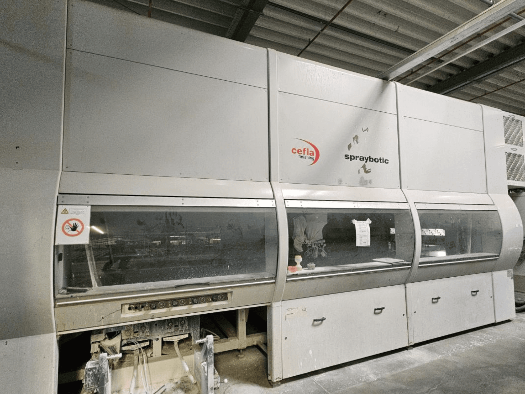 Výrobní linka Cefla Spraybotic MD na dřevo, pohled zepředu, s ovládacím panelem a průhledovými okénky.