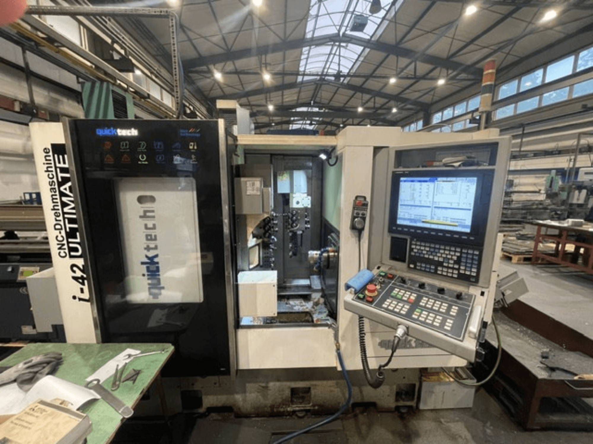 Soustruh Quick-Tech I-42U švýcarského typu, pohled zepředu, ukázka ovládacího panelu a rozhraní CNC v dílenském prostředí.