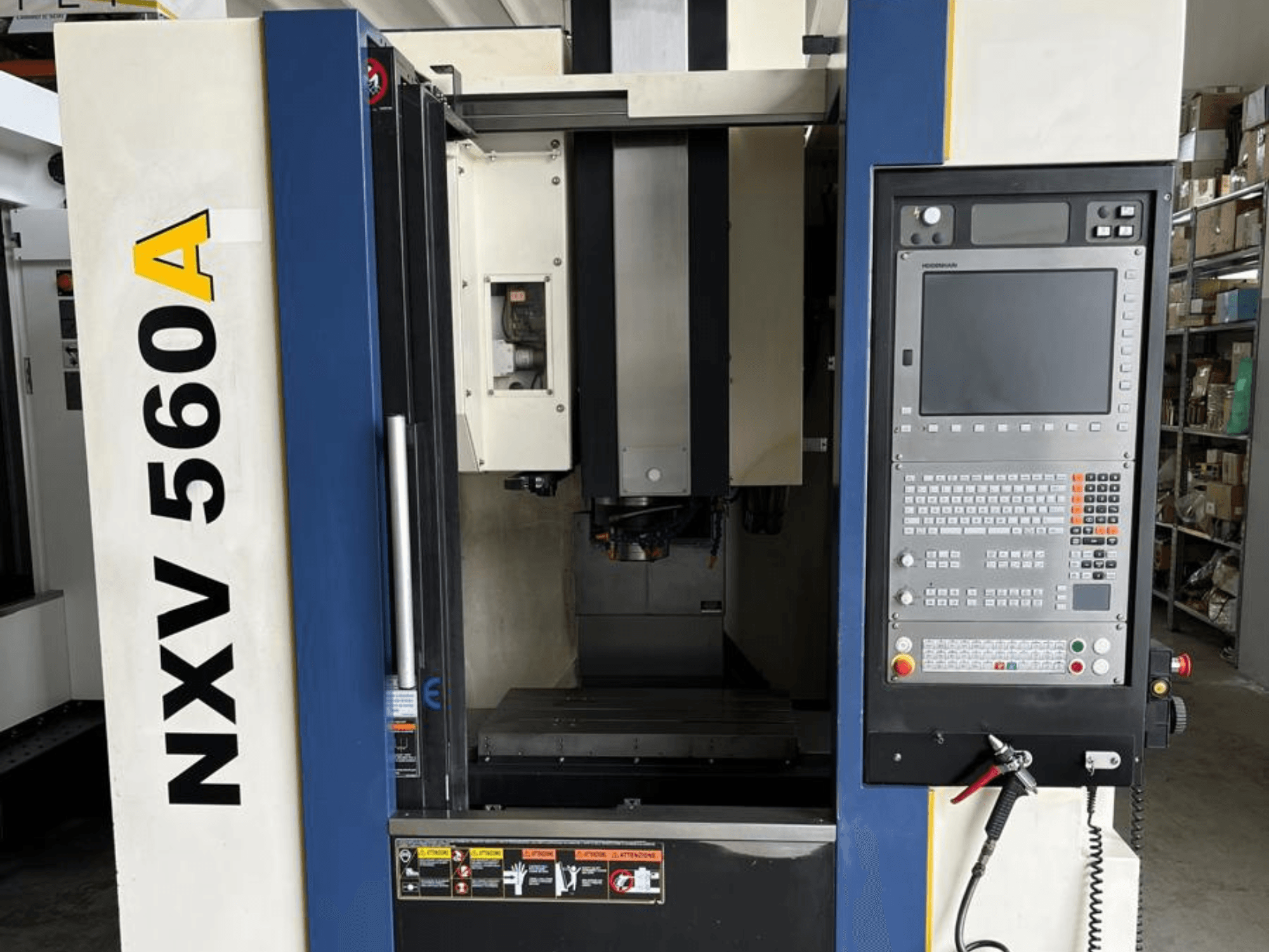 CNC stroj NXV 560A při pohledu zepředu, s ovládacím panelem s tlačítky a digitálním displejem.