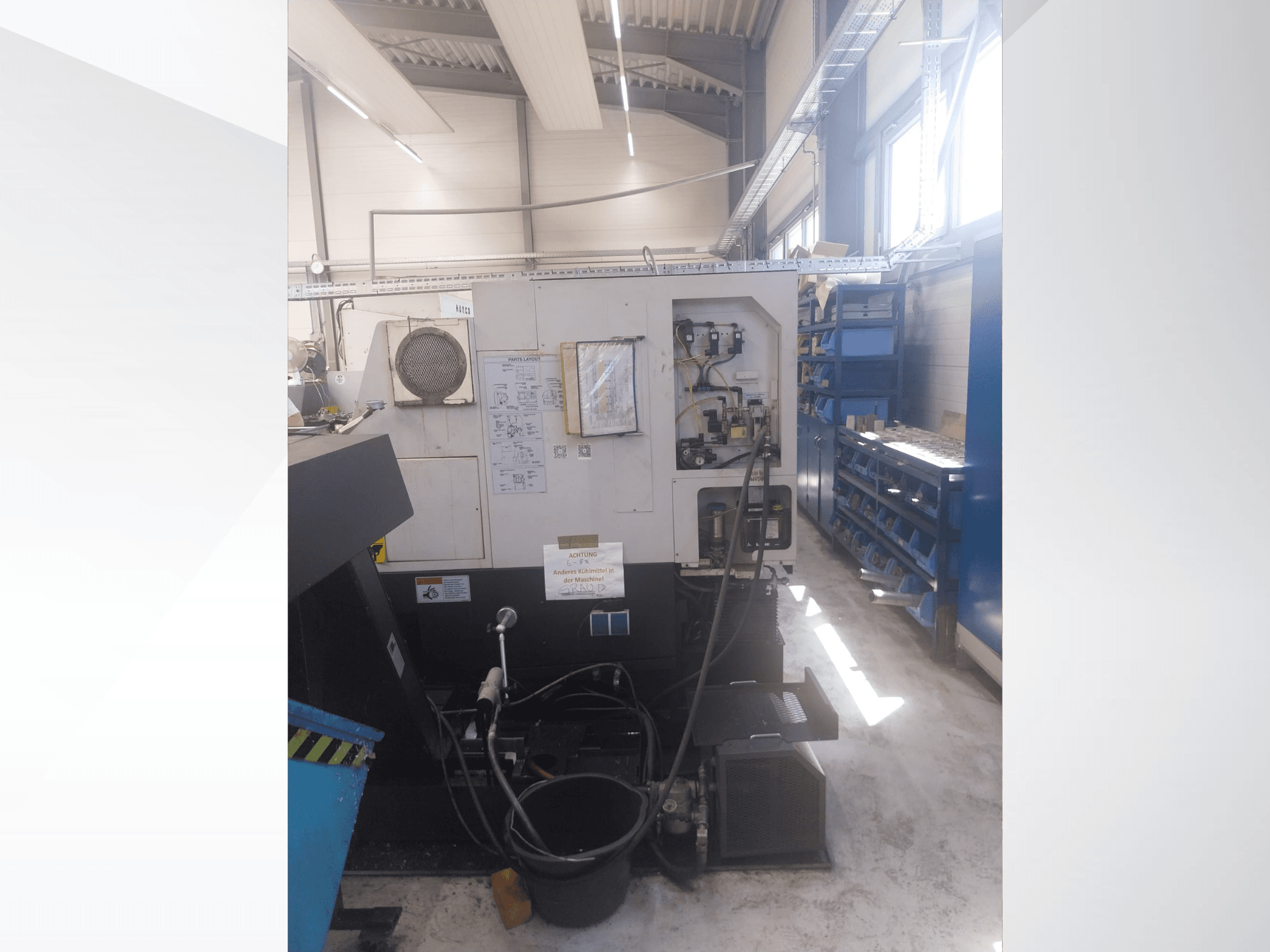 Mazak QUICK TURN NEXUS 200 MS, boční pohled znázorňující ovládací panel, hadice a prostor pro nástroje v dílenském prostředí.