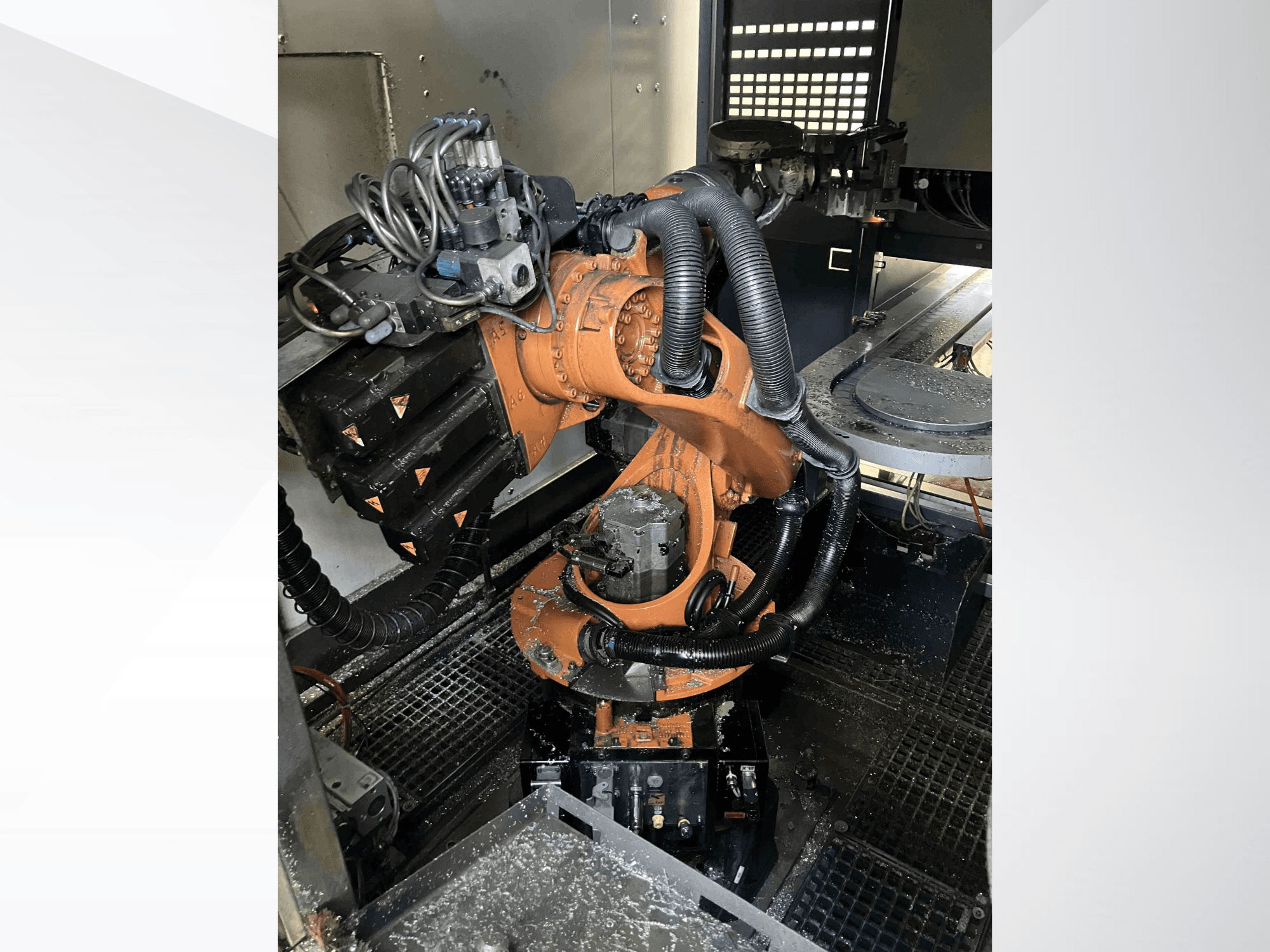 Robotické rameno KUKA KR 16 z horního úhlu, na kterém jsou vidět mechanické součásti a zapojení v dílenském prostředí.