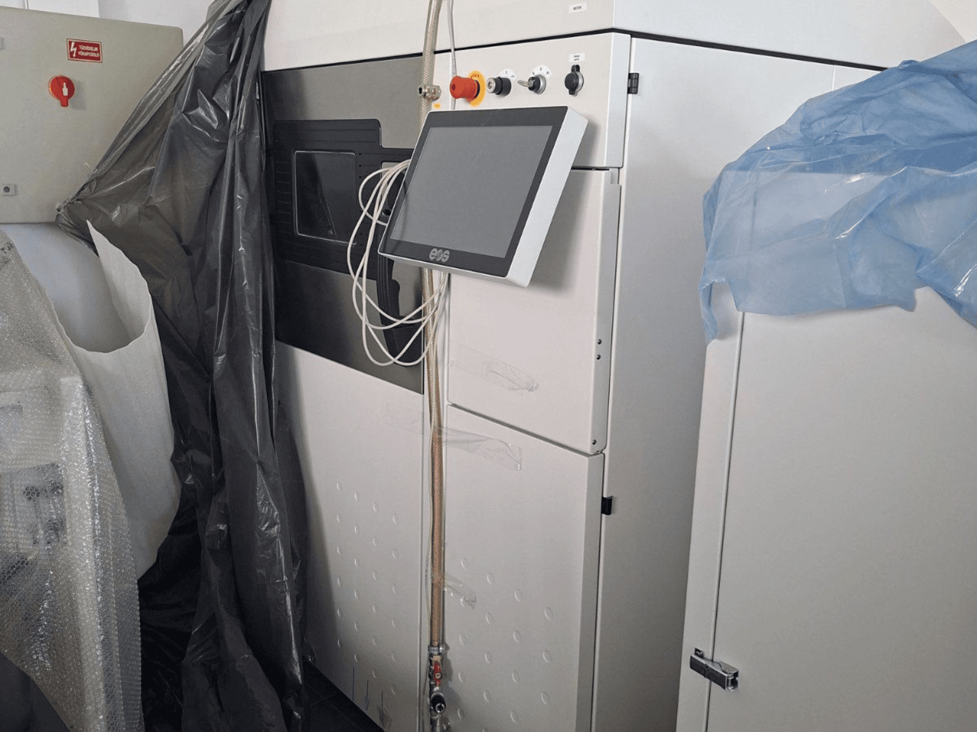 Kovová 3D tiskárna EOS M 290, pohled zepředu, s dotykovým displejem, ovládacím panelem a ochrannými kryty.