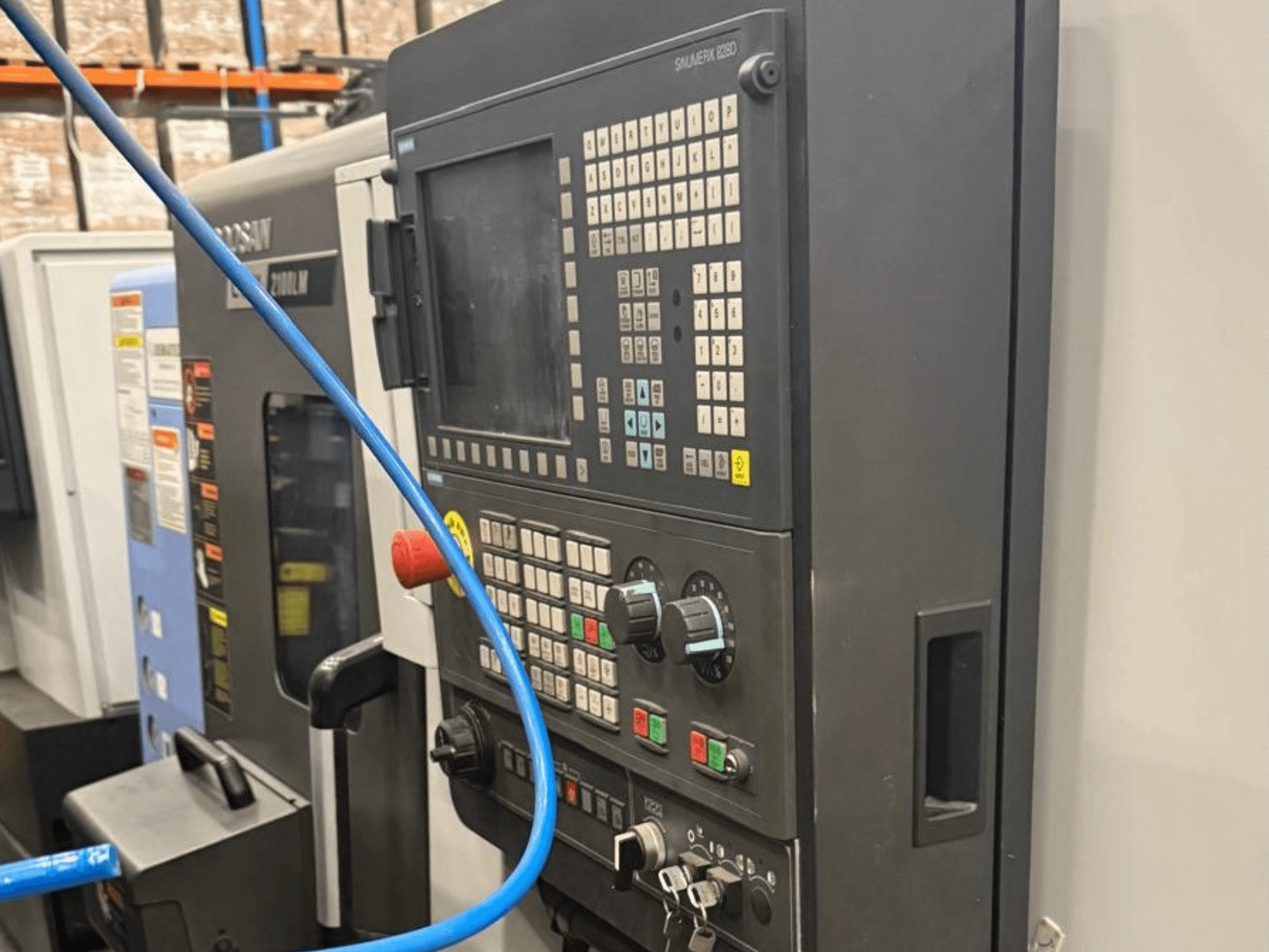 Ovládací panel obráběcího nástroje, pohled zepředu, s tlačítky, knoflíky a digitálním displejem pro přesné ovládání.