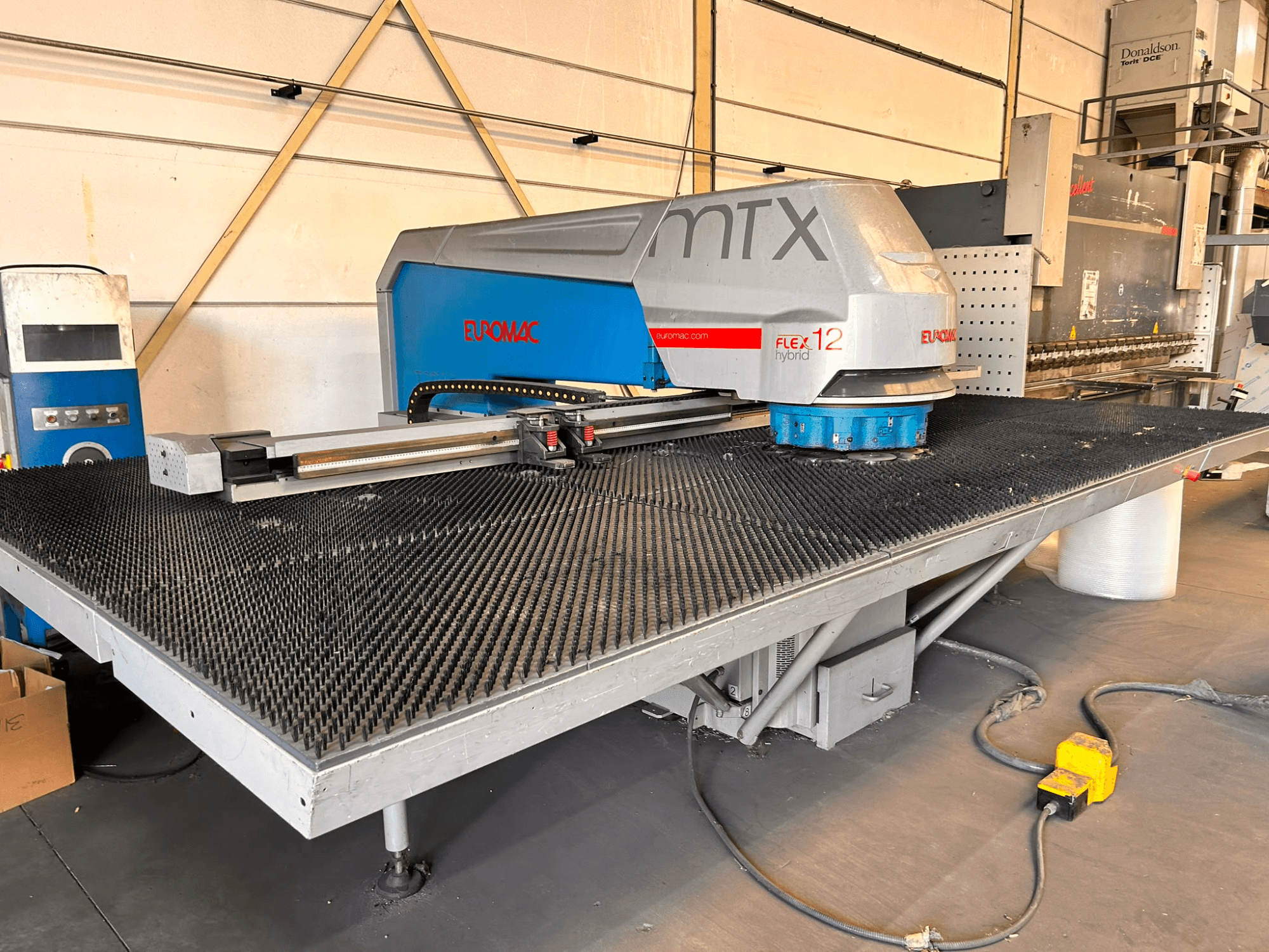 CNC děrovací stroj Euromac MTX FLEX 12, pohled zepředu, s velkým perforovaným stolem a ovládacím panelem.