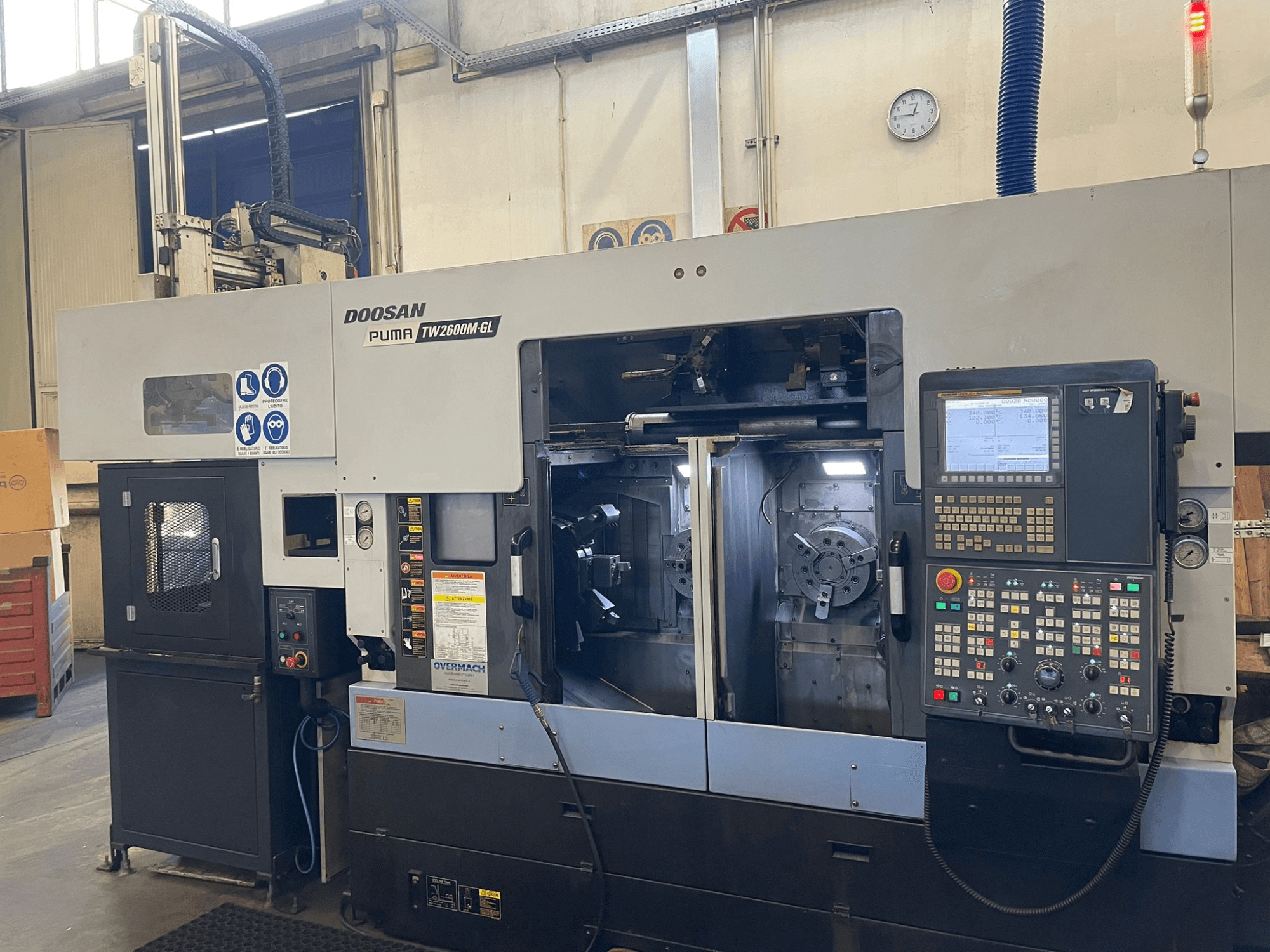 CNC soustruh Doosan Puma TW2600M GL, pohled zepředu, digitální ovládací panel a vnitřní prostor stroje s držáky nástrojů.