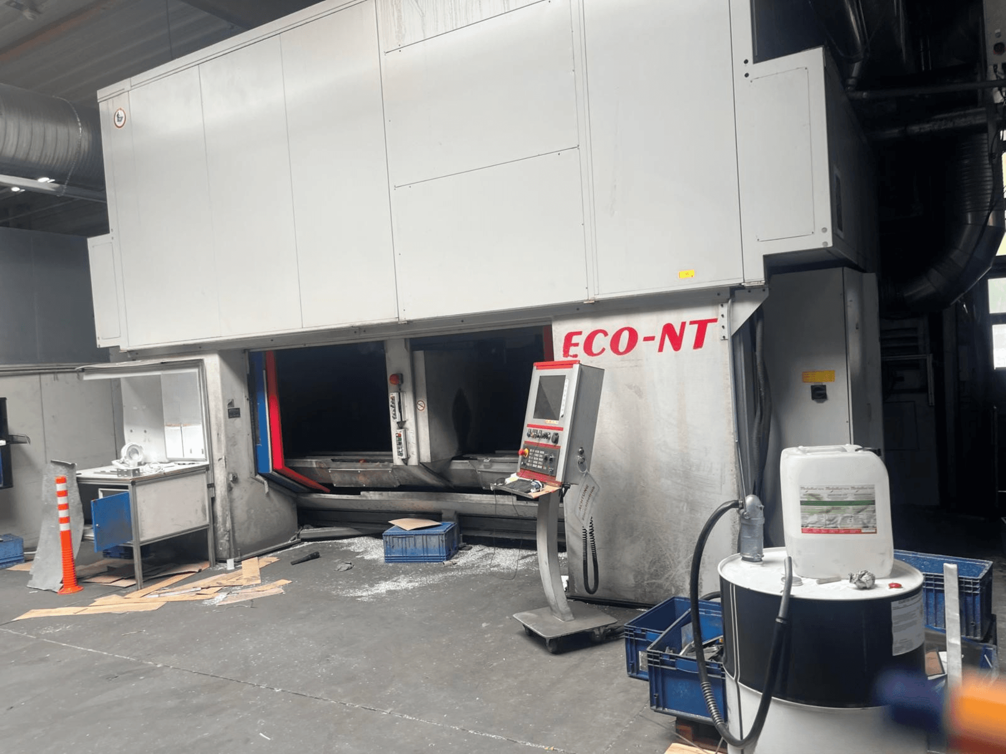 Pohled zepředu na vertikální obráběcí centrum Hamuel Reichenbacher ECO-NT, na kterém je vidět ovládací panel, nádrž na chladicí kapalinu a pracovní prostor.