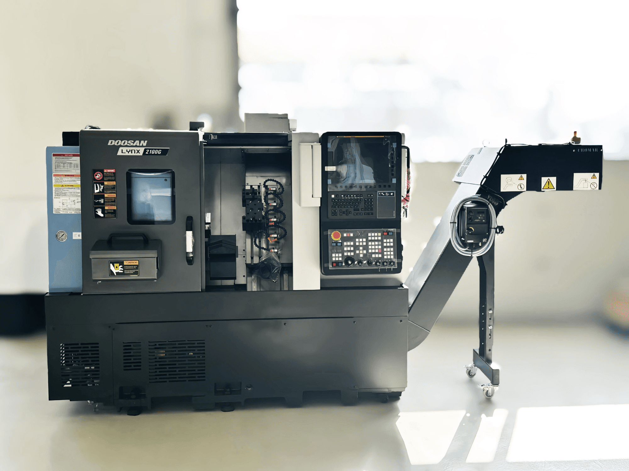 Soustruh švýcarského typu DOOSAN LYNX 2100GA v bočním pohledu s viditelným ovládacím panelem a držákem nástrojů.