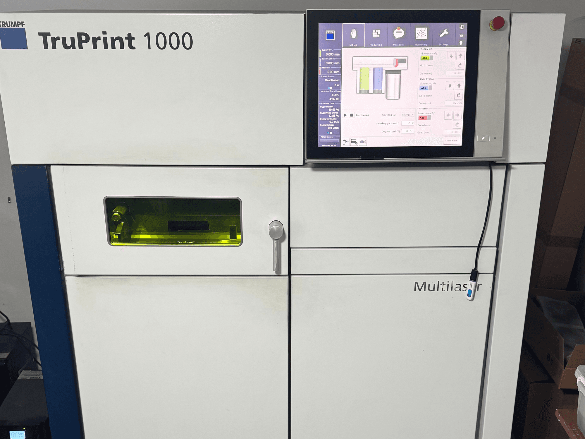 TruPrint 1000 od společnosti Trumpf, pohled zepředu, s digitálním ovládacím panelem a průhledným kontrolním okénkem pro sledování.