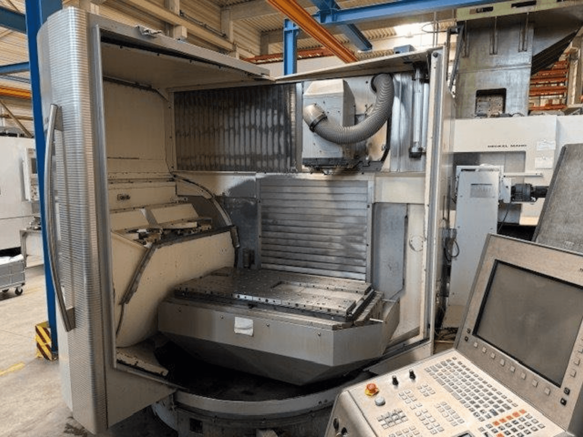 Vertikální obráběcí centrum DMG MORI DMU 80T, pohled zepředu ukazuje otevřenou skříň a ovládací panel.