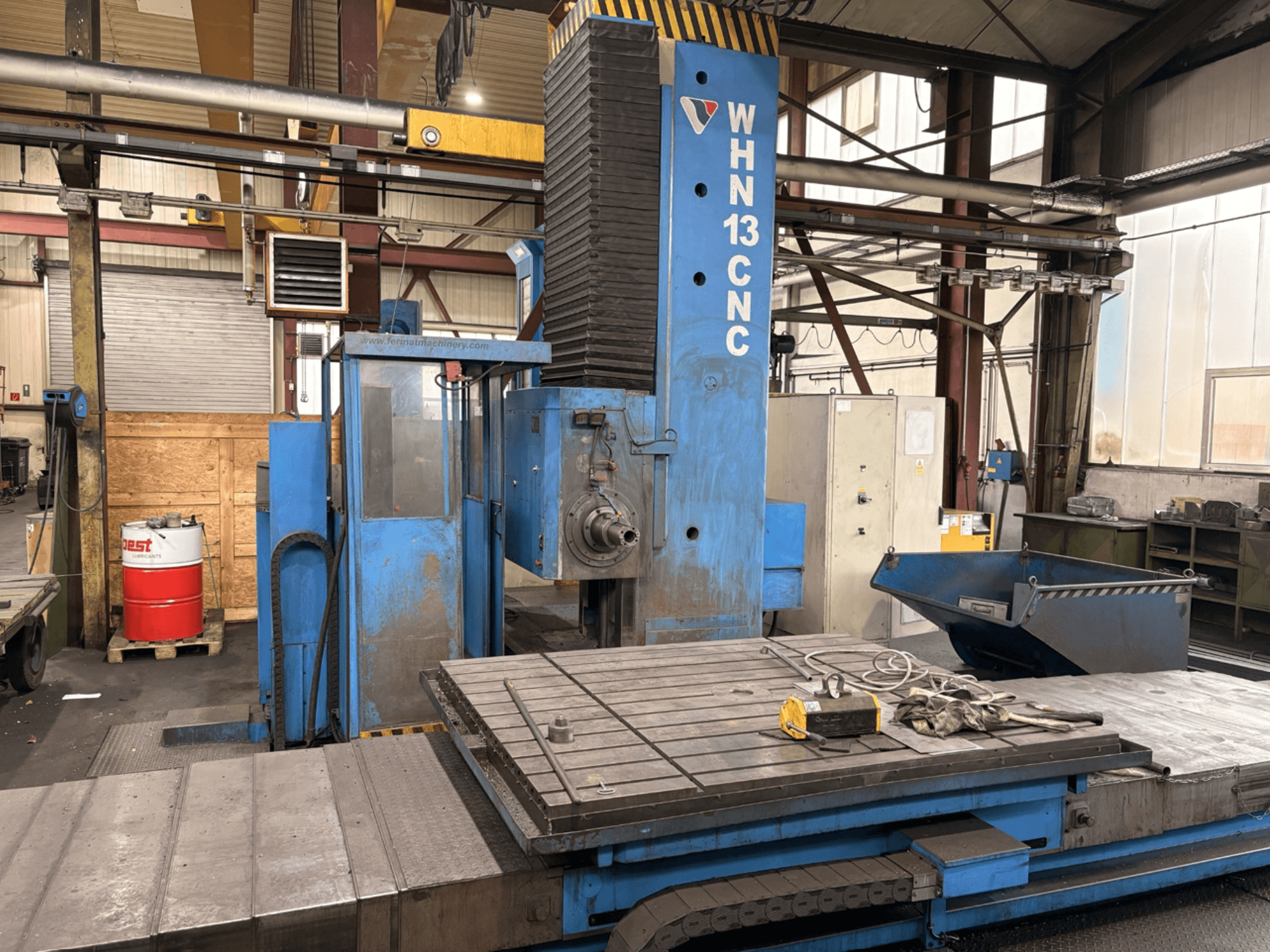 Horizontální obráběcí centrum FERMAT WHN 13.8 s řízením CNC, pohled zepředu znázorňující ovládací panel, pracovní stůl a detaily průmyslového prostředí.