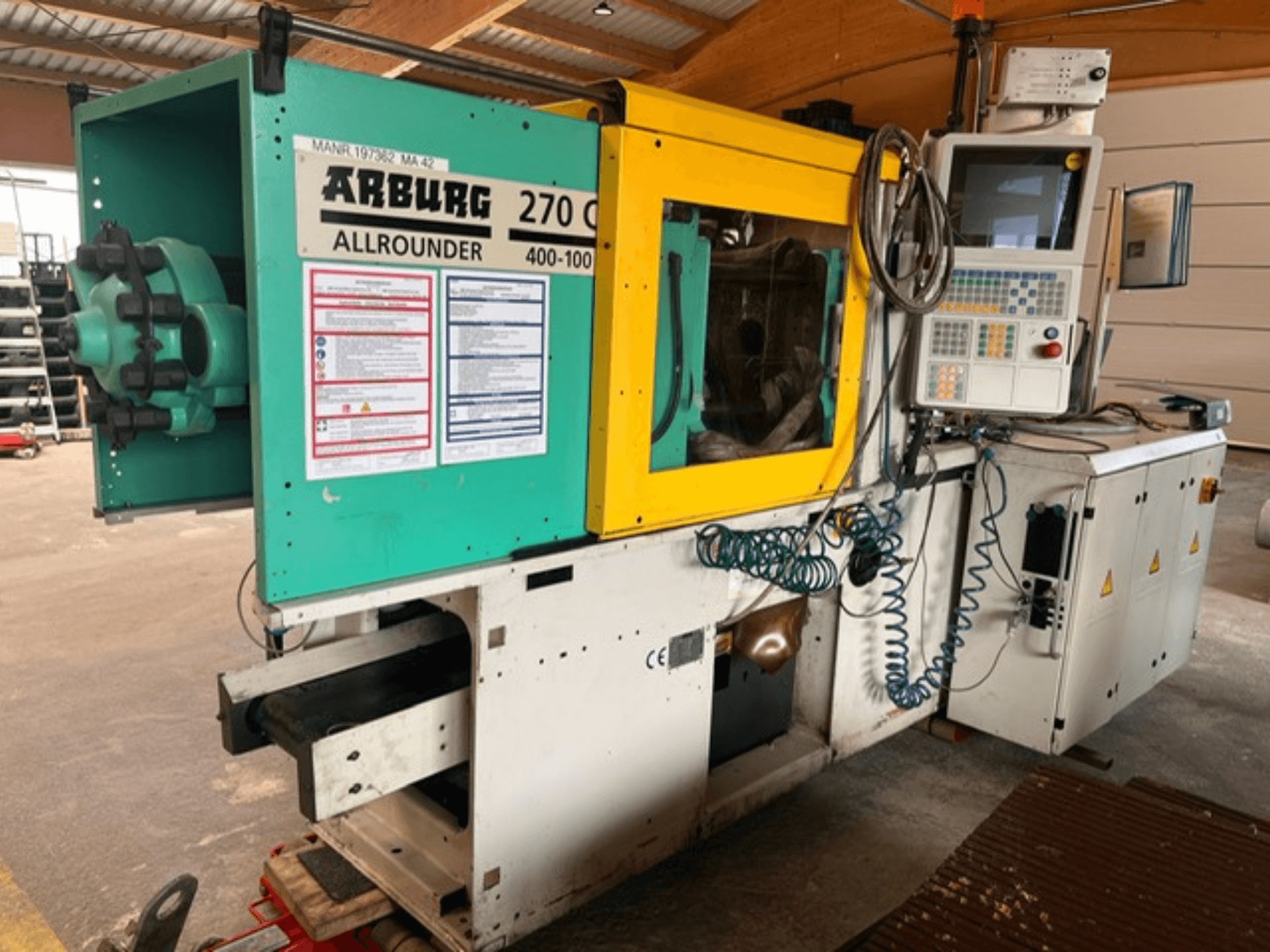 Pohled zepředu na hydraulický vstřikovací stroj Arburg 270 C s ovládacími prvky a provozními detaily.