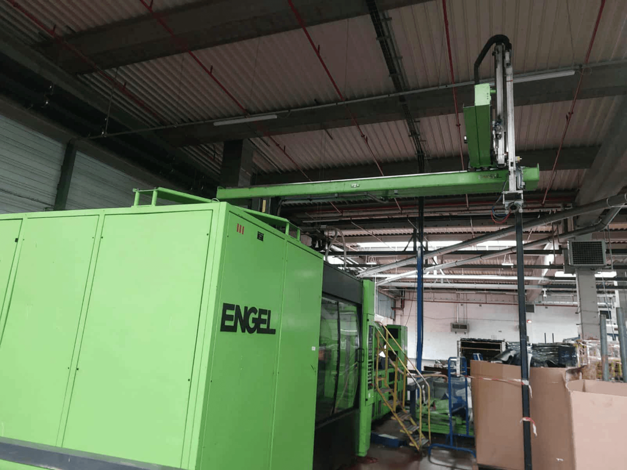 Zelený hydraulický vstřikovací stroj Engel ES 16050/1100 DUO, boční pohled na ložnou plochu a ovládací panel.