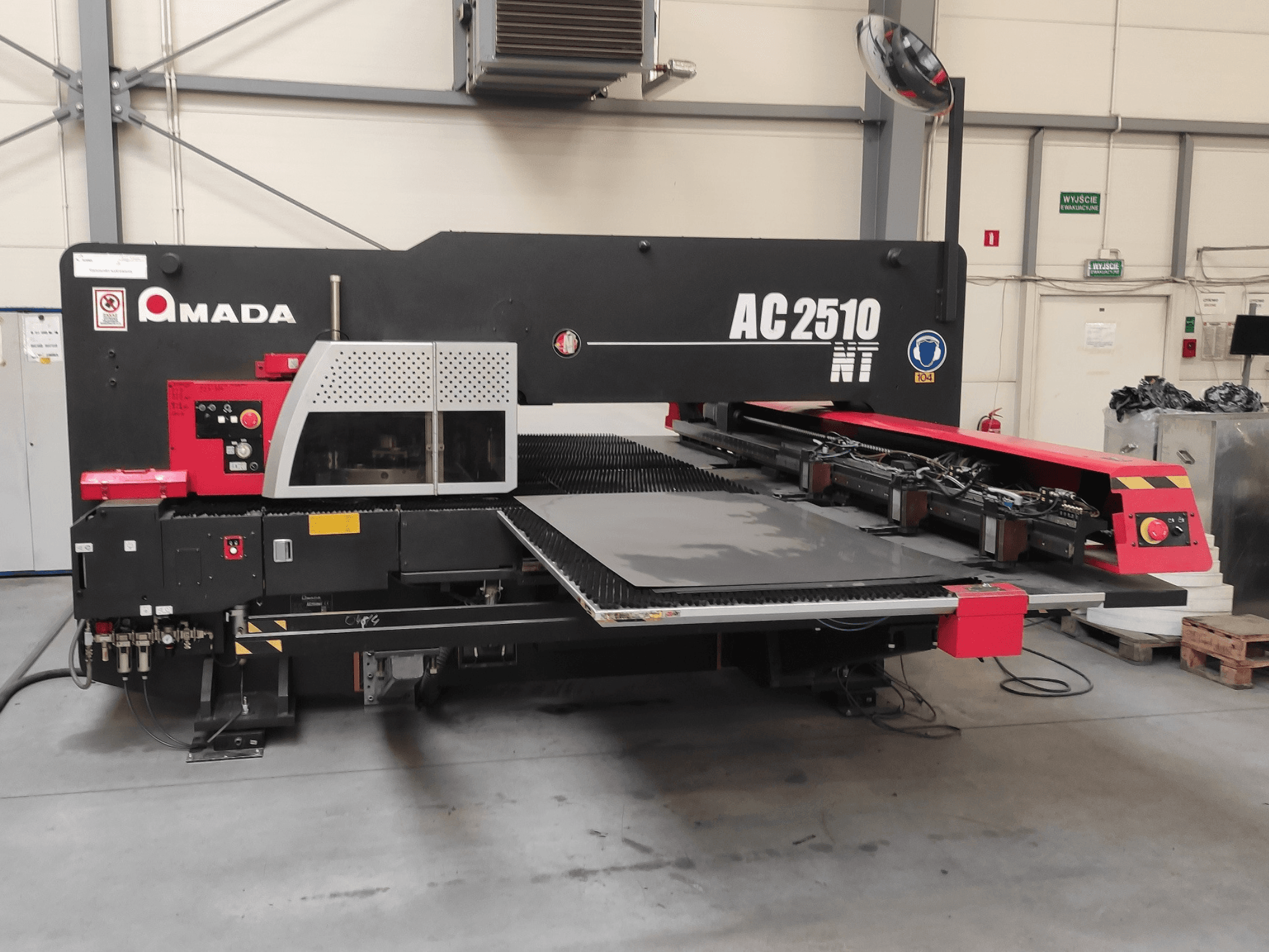 Děrovací stroj Amada AC2510 NT CNC, pohled zepředu, s ovládacím panelem a prostorem pro vkládání plechů.