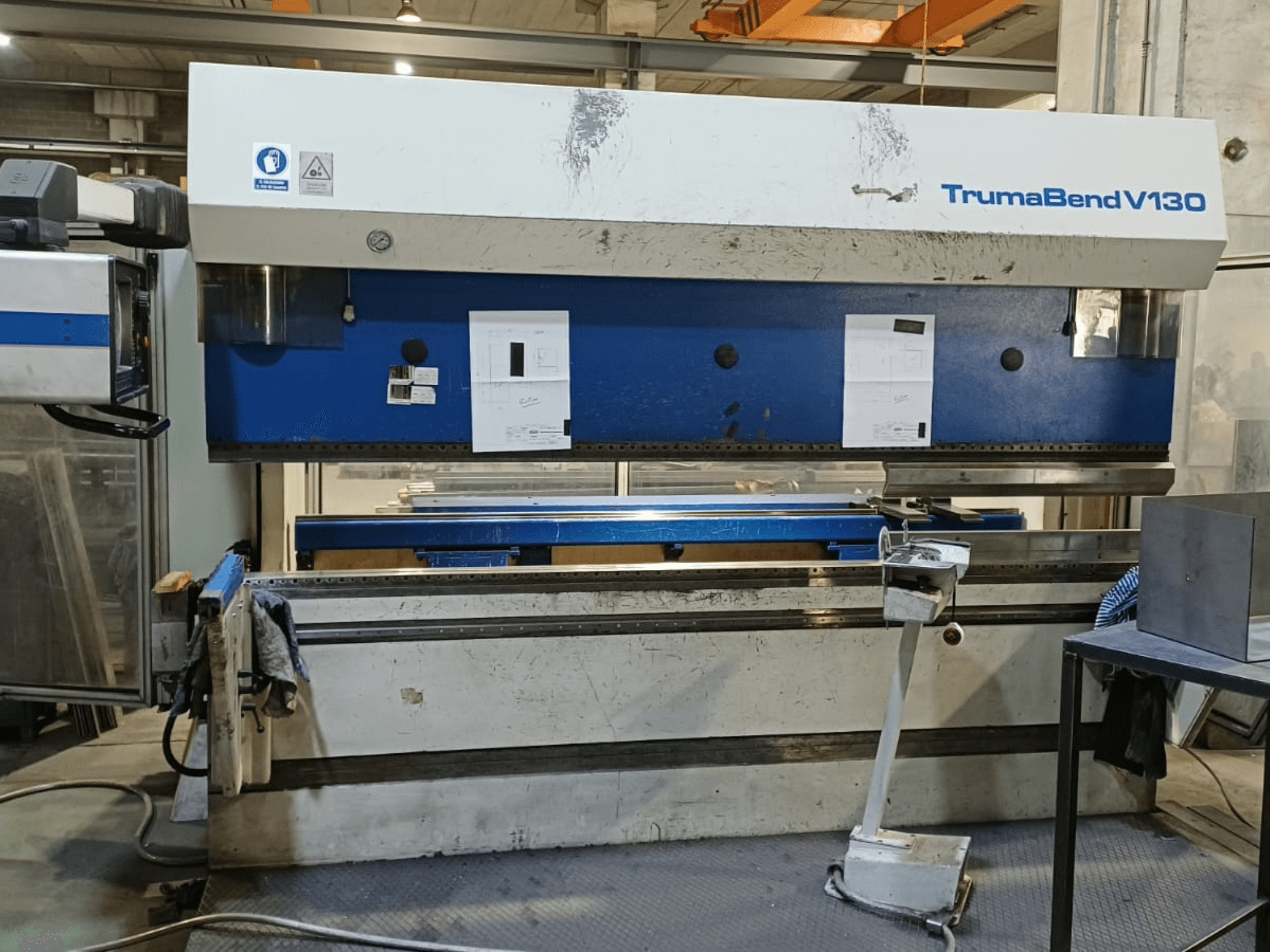 Ohýbačka TRUMPF Trumatic Trumabend V130 v čelním pohledu, na kterém je vidět ovládací panel, pracovní plocha a nastavitelné nástroje.