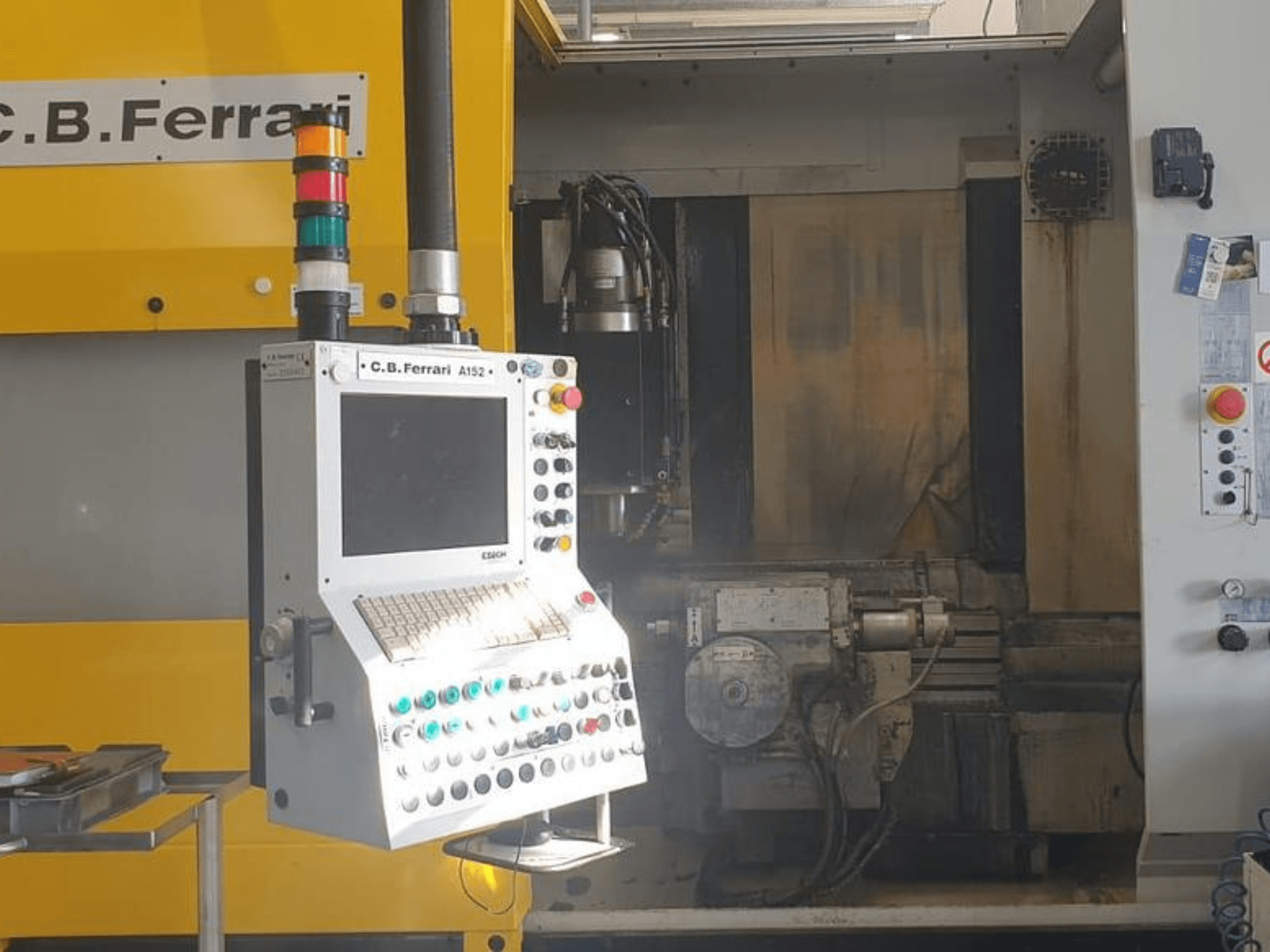 Vertikální obráběcí centrum C.B. Ferrari A152, pohled zepředu, ovládací panel s tlačítky a komponenty motoru na stroji.