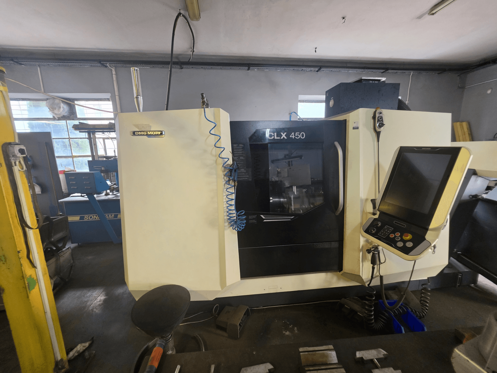 Horizontální soustruh DMG MORI CLX 450 V6 v čelním pohledu, s ovládacím panelem a viditelným logem značky.