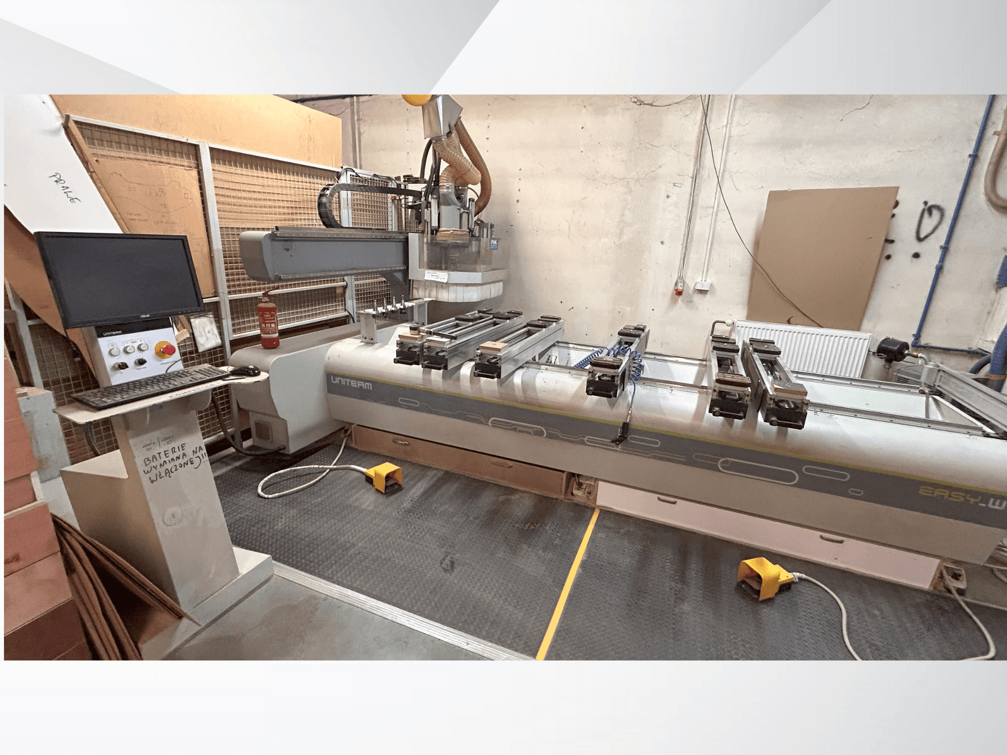 Pohled zepředu na CNC stroj UNITEM EASY-W s ovládacím panelem, monitorem a upnutými obrobky na pracovním stole.