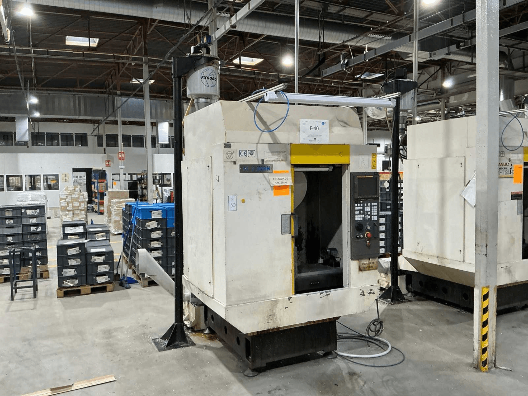 FANUC ROBODRILL α-T21iD, čelní pohled na vertikální obráběcí centrum v průmyslovém prostředí, s viditelnými detaily ovládacího panelu.