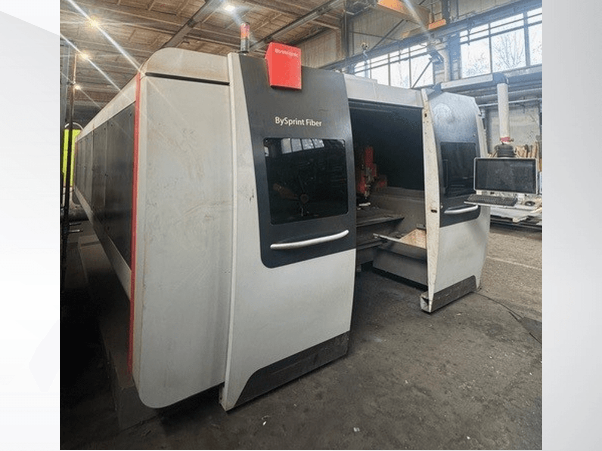 Stroj BySprint Fiber od společnosti Brünswick, pohled zepředu ukazuje dva otvory, dotykový ovládací panel a průmyslový pracovní prostor uvnitř.