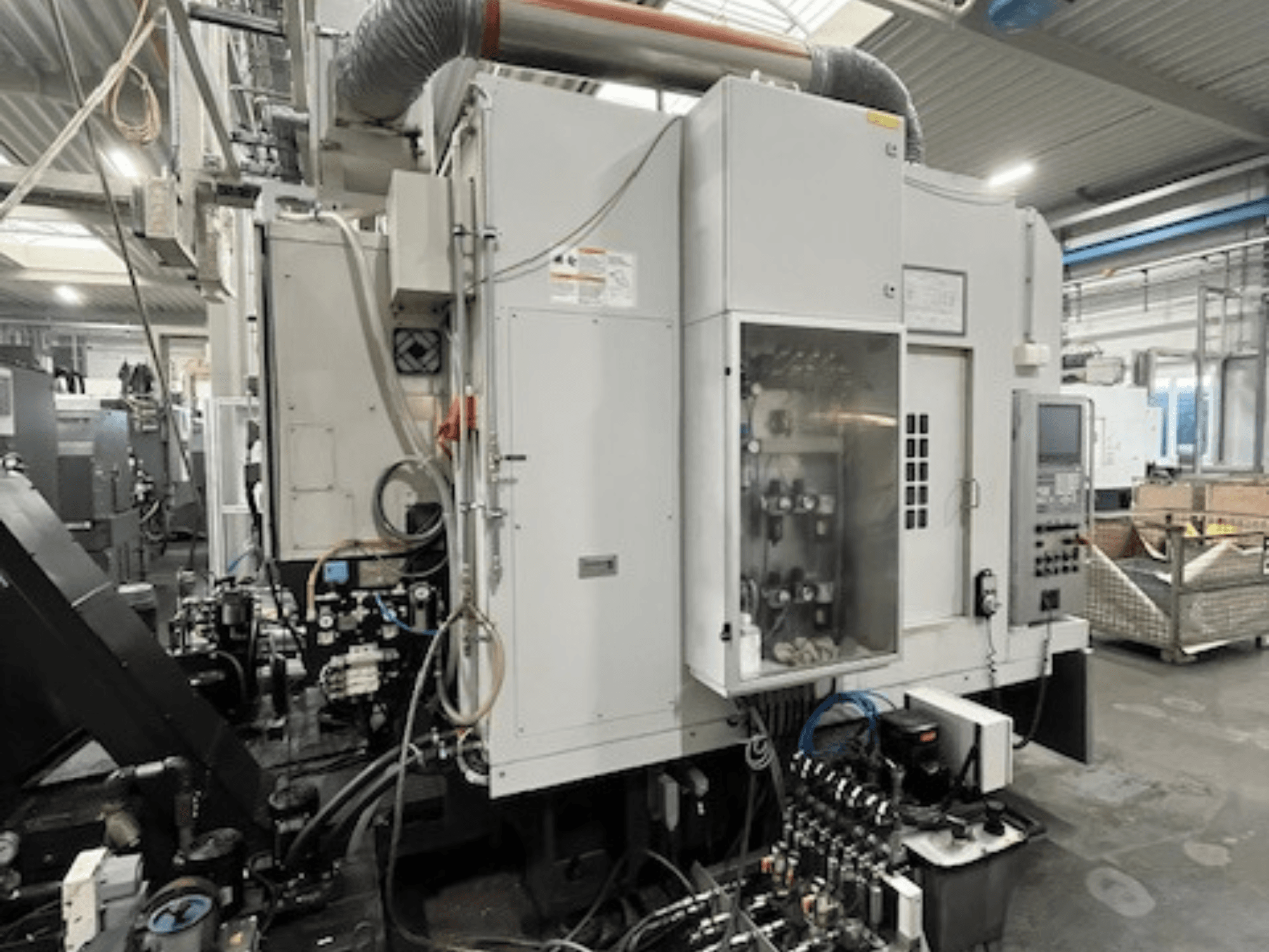 Boční pohled na průmyslový stroj s ovládacím panelem a hydraulickými komponenty, s detaily značky a modelu.