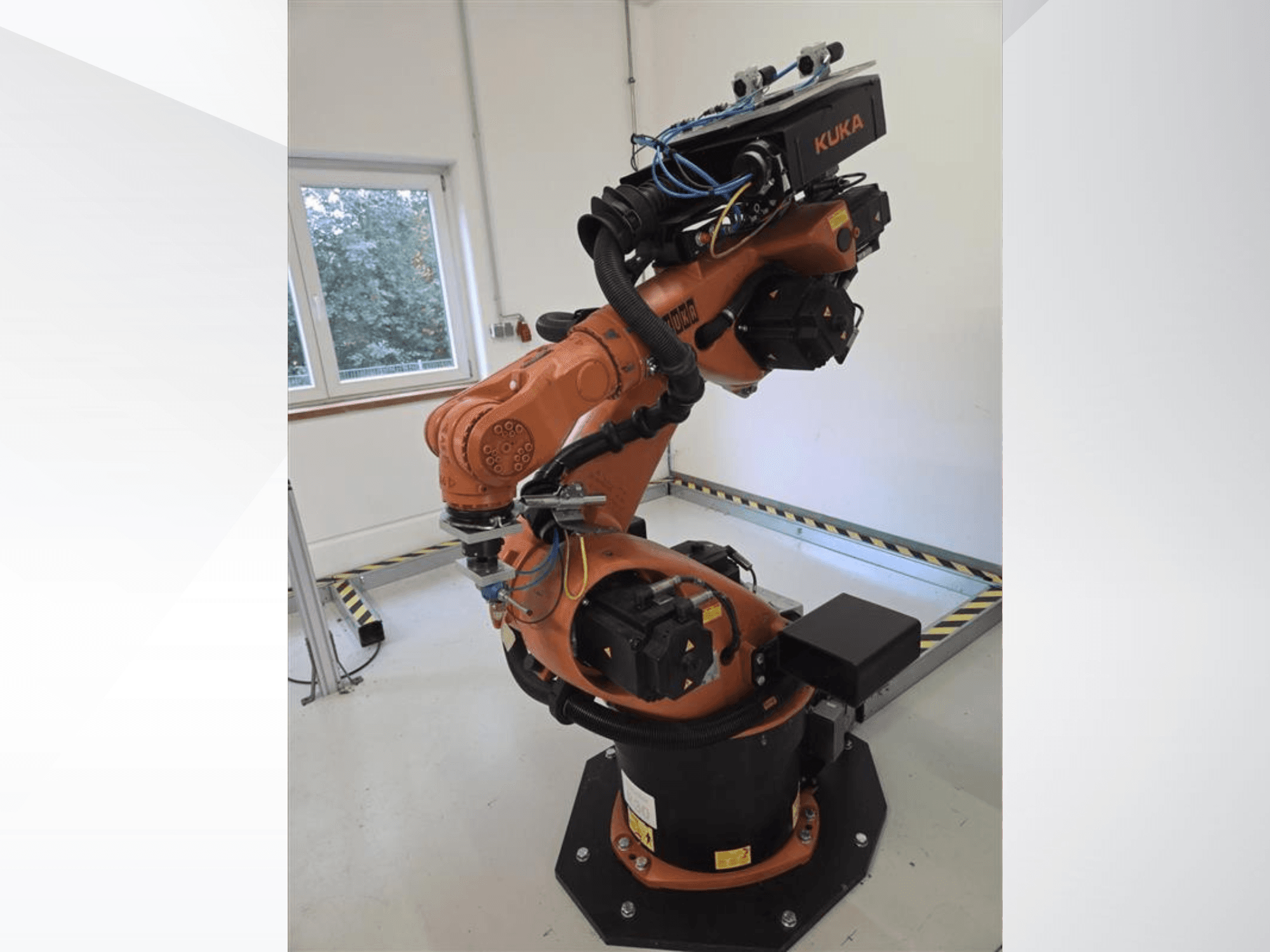 Robotické rameno KUKA KR60 HA v bočním pohledu, na kterém jsou vidět mechanické klouby a kabeláž na průmyslové základně.