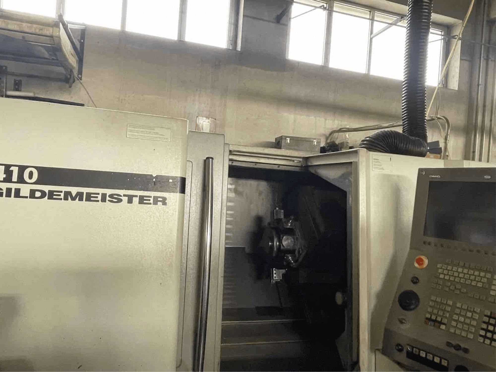 Horizontální soustruh DMG CTX410, pohled zepředu, zobrazující ovládací panel a viditelné obráběcí komponenty uvnitř.