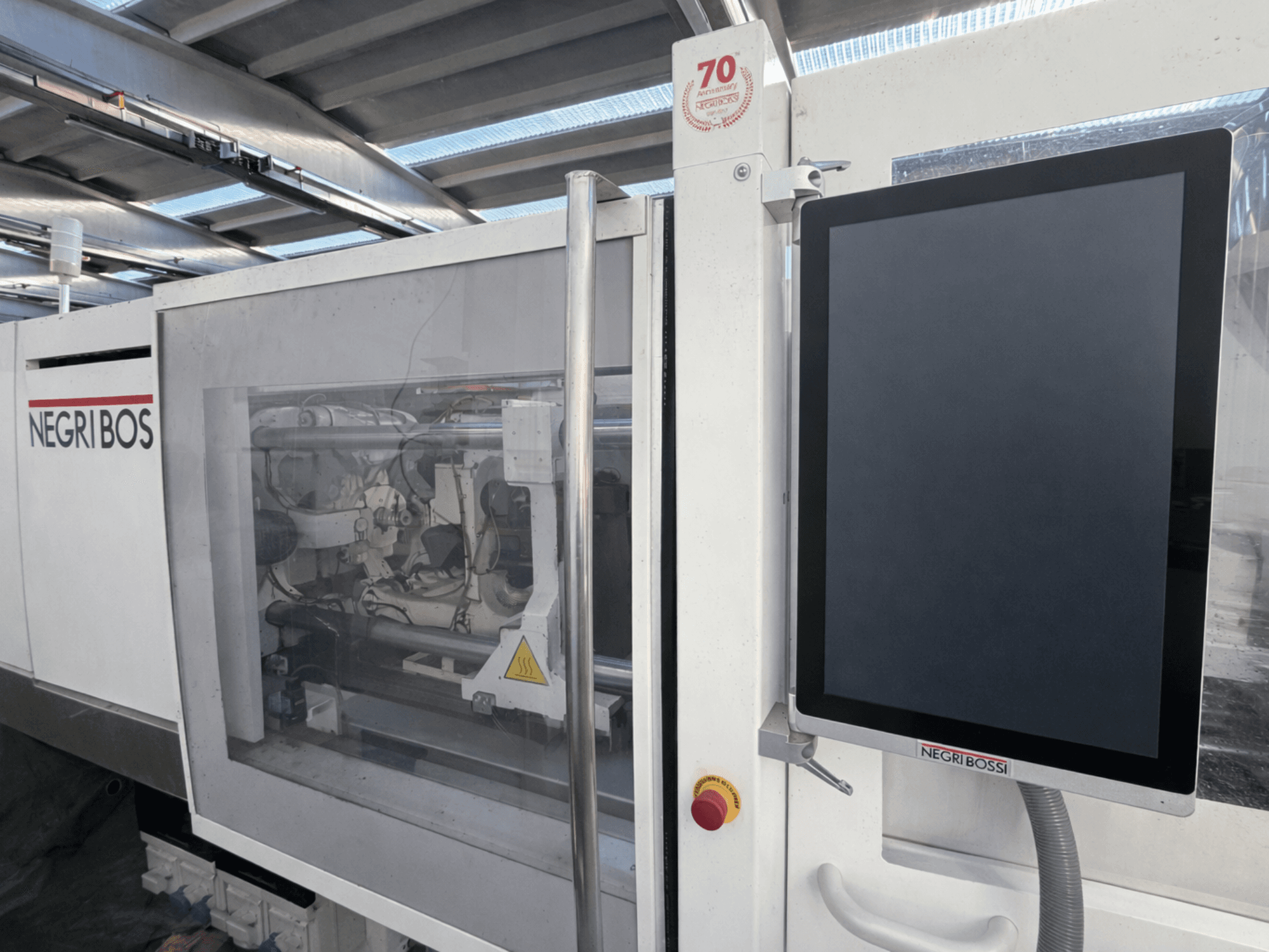 Elektrický vstřikovací stroj Negri Bossi ELE 80, pohled zepředu s ovládacím displejem a viditelnými vnitřními součástmi.