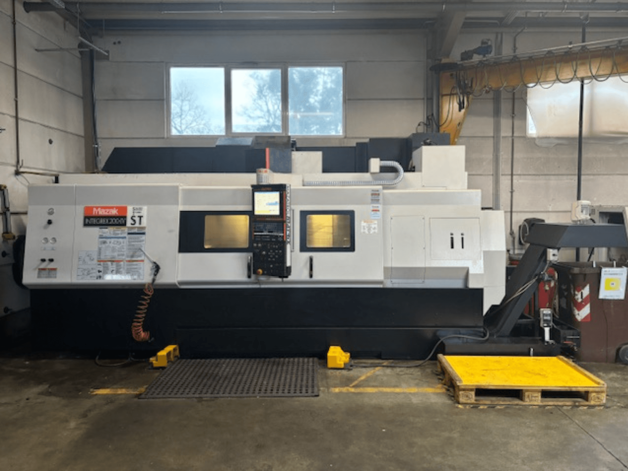 Mazak Integrex 200 SY ST, boční pohled, zobrazující ovládací panel, provozní displeje a vedení chladicí kapaliny v dílenském prostředí.