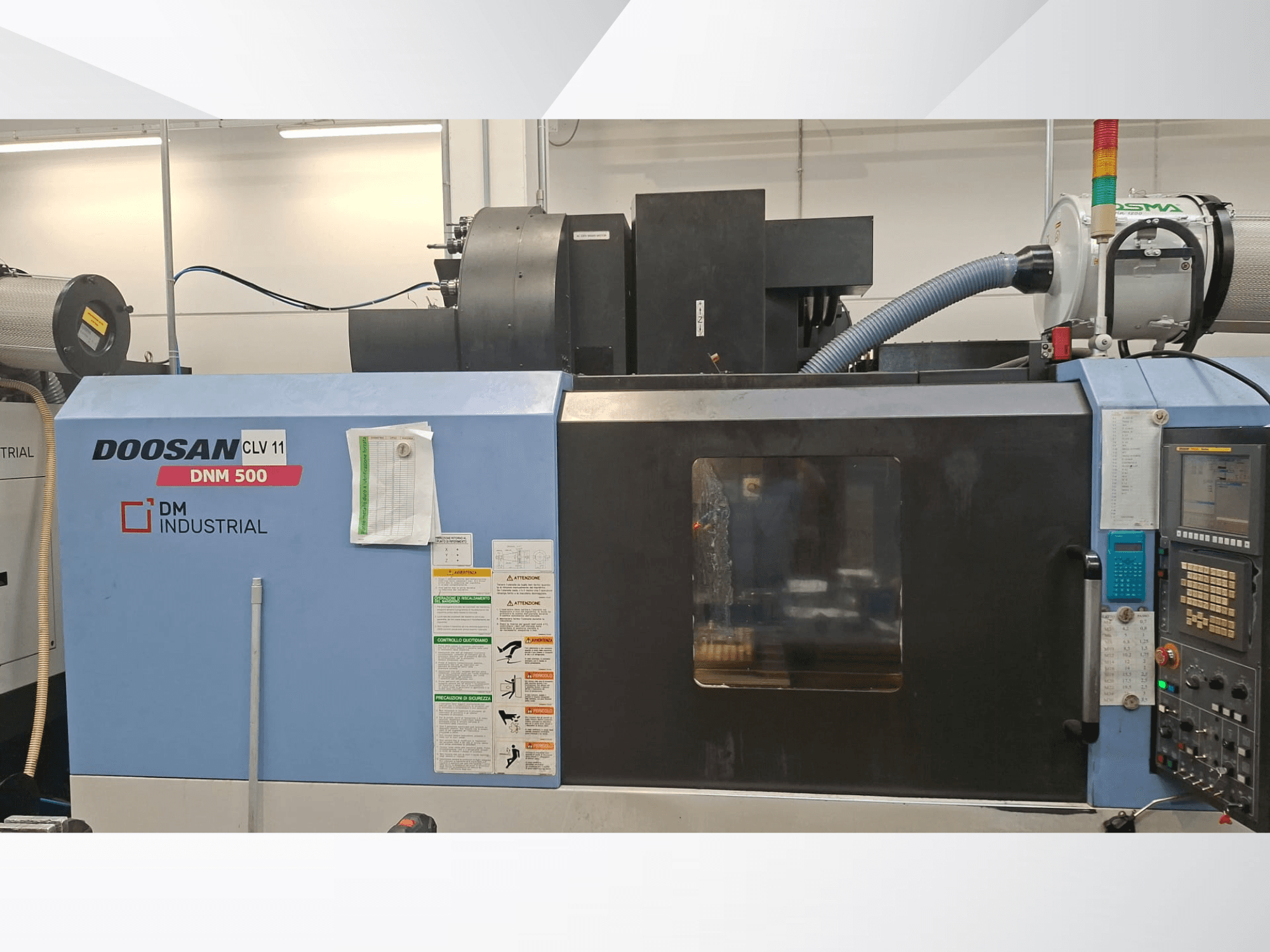 Vertikální obráběcí centrum DOOSAN DNM 500 z bočního pohledu, s ovládacím panelem a funkčními částmi.