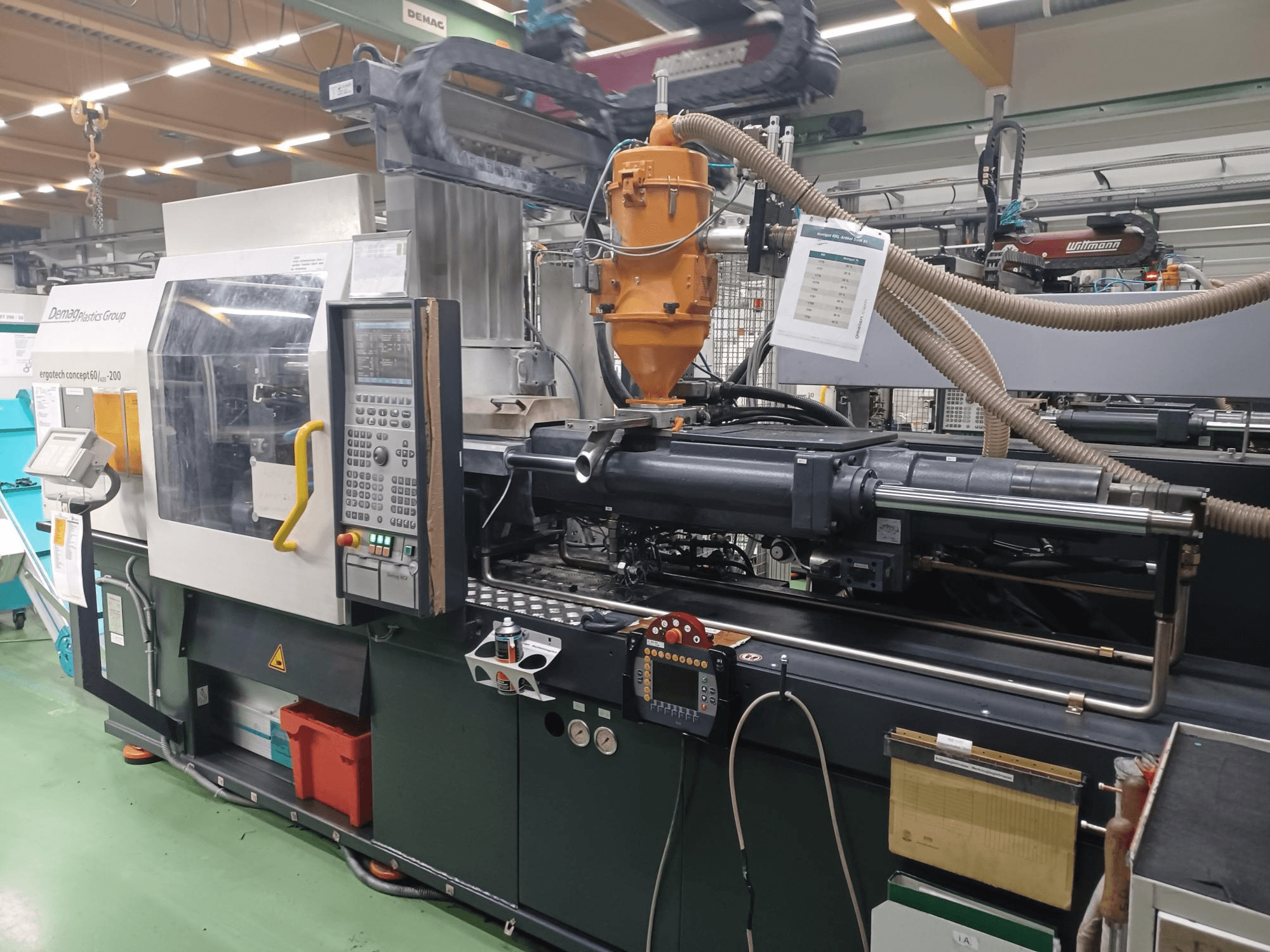 Vstřikovací stroj Demag Ergotech 200, pohled zepředu, s viditelným ovládacím panelem, tryskou a provozními prvky.