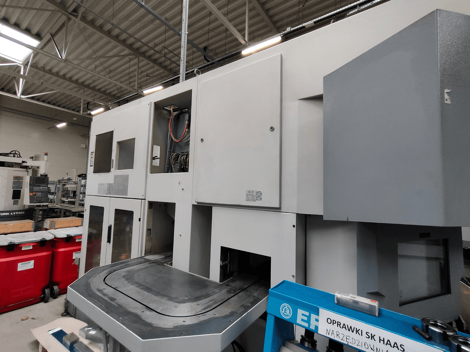 Vertikální soustruh EMAG VSC 250 zobrazený z boku, s ovládacími panely a velkou pracovní plochou.