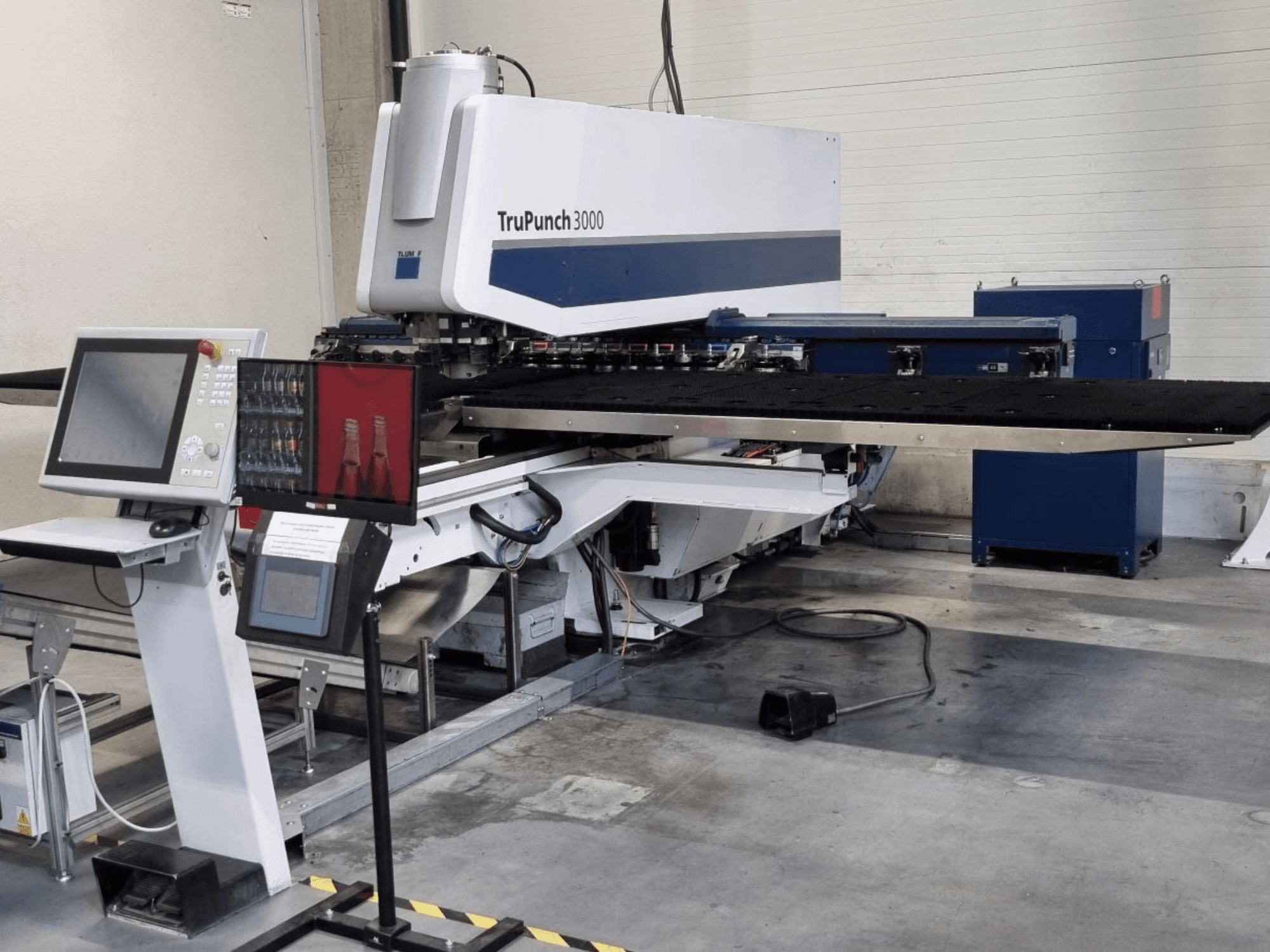 CNC děrovací stroj TRUMPF TruPunch 3000 v čelním pohledu, s ovládacím panelem a velkým děrovacím stolem.