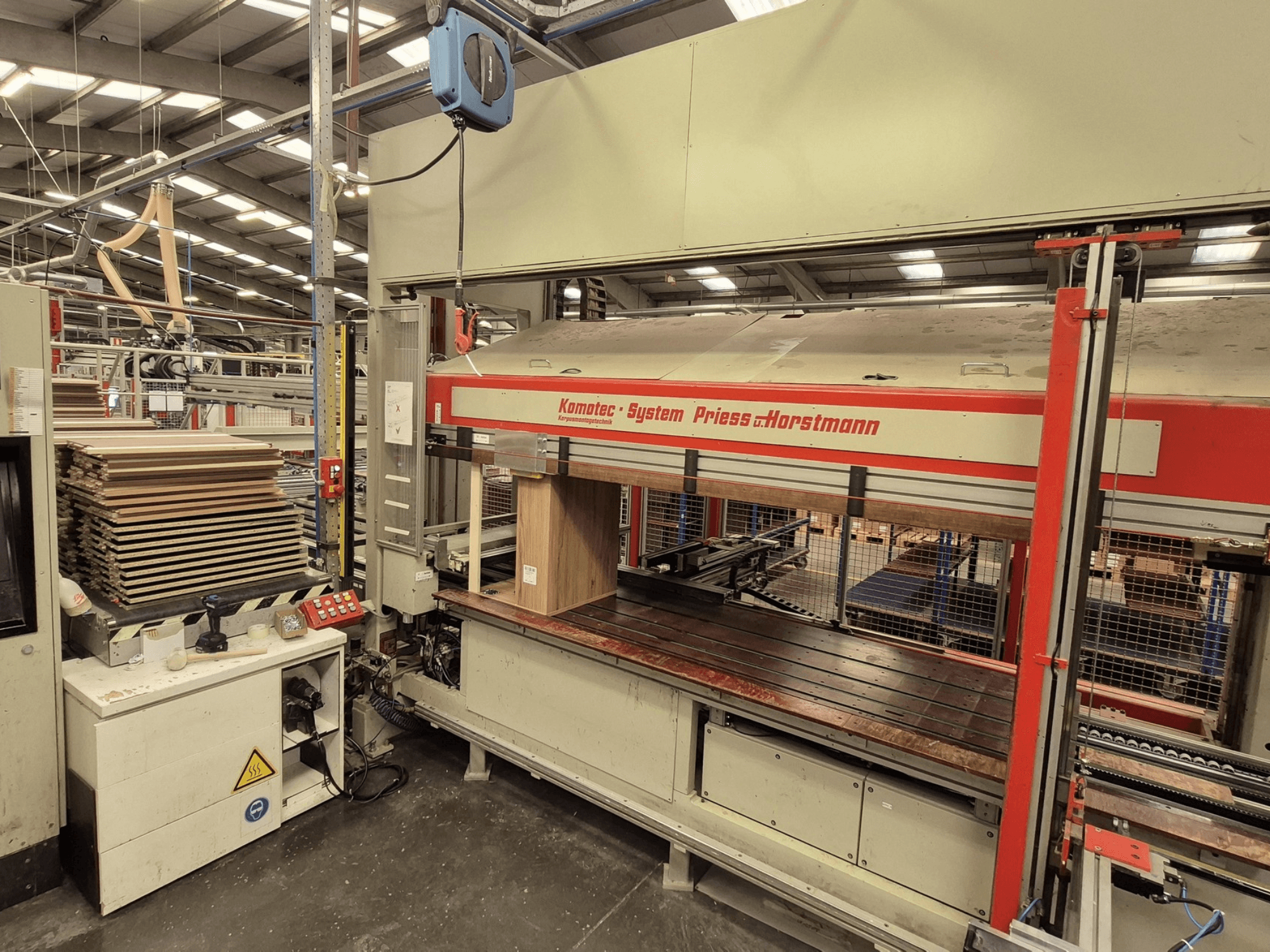 Dýhovací lis KP-5-CNC od PREISS U HORTSTMANN, pohled zepředu, ukazuje naskládané dýhové listy a ovládací panel.