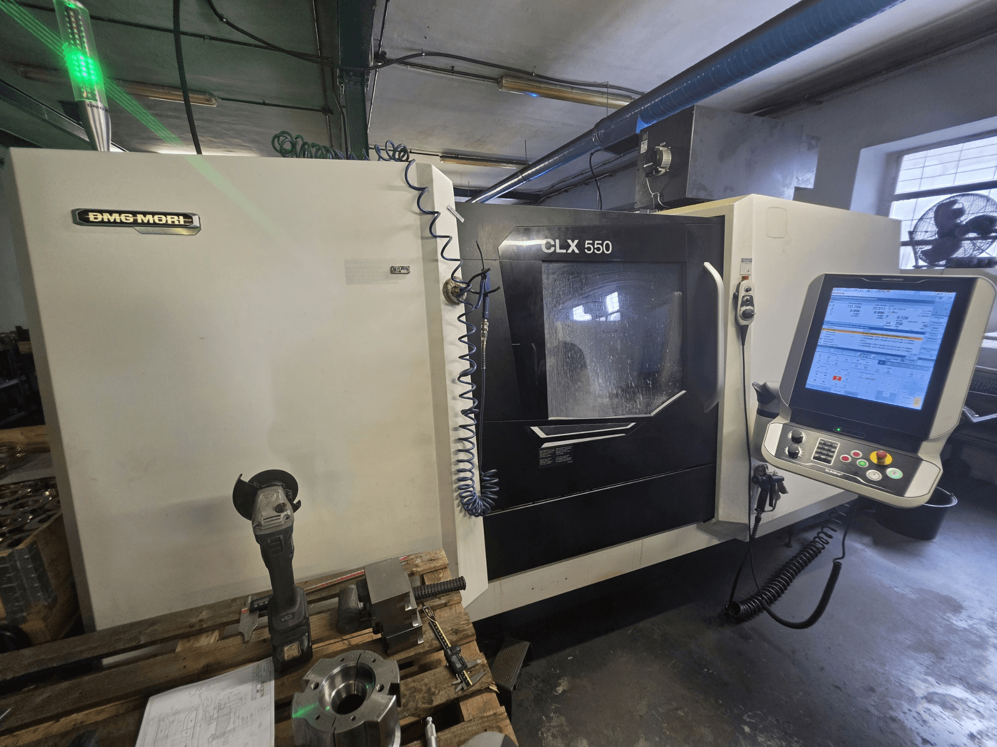 Horizontální soustruh DMG MORI CLX 550 V3, pohled zepředu znázorňující ovládací panel, řezné nástroje a skříň stroje.