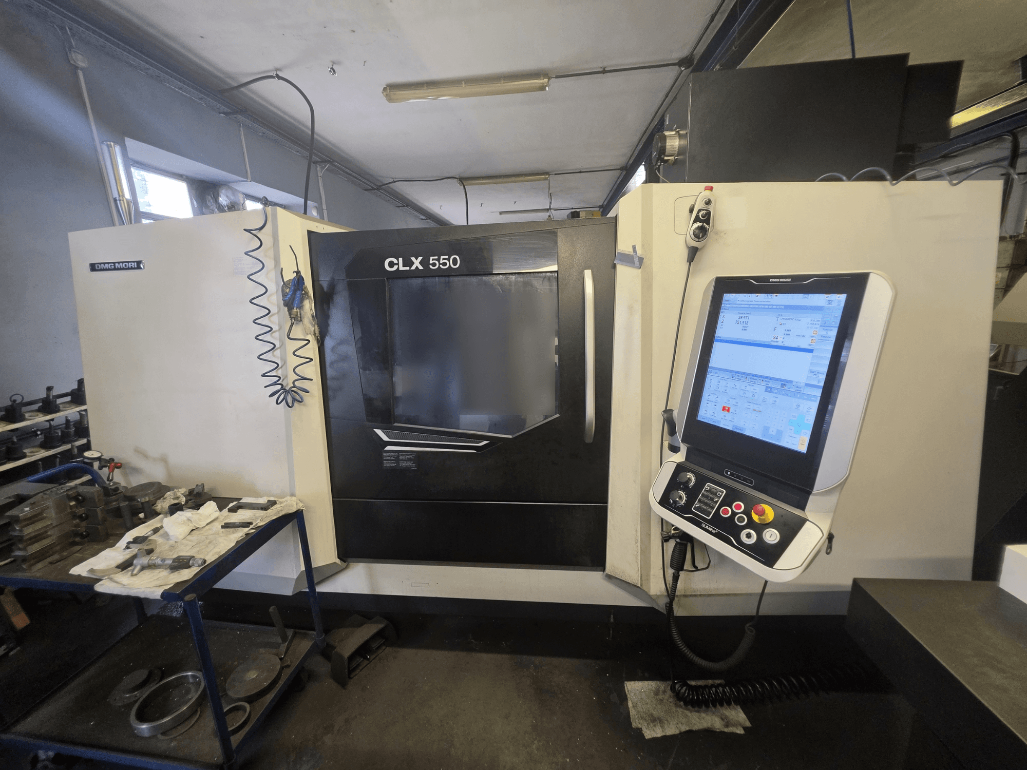 Horizontální soustruh DMG MORI CLX 550 V3, pohled zepředu, na kterém je vidět ovládací panel a pracovní prostor s nástroji.