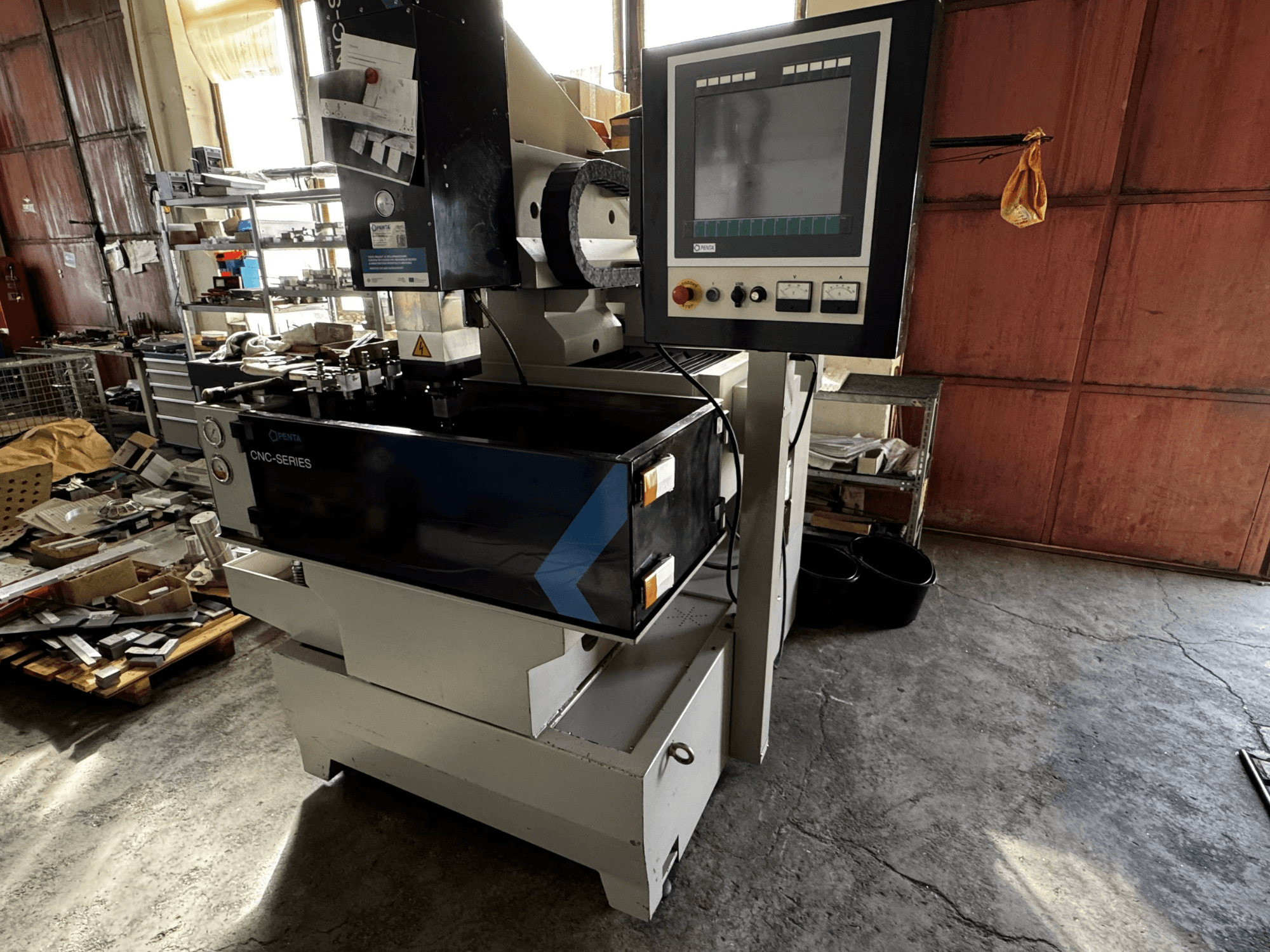 CNC elektroerozivní stroj PENTA 433GS, pohled zepředu. Zobrazuje ovládací panel, držák elektrod a kovový pracovní stůl.