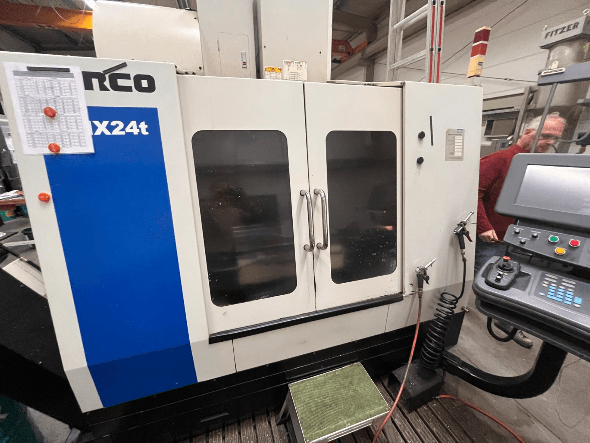 Vertikální obráběcí centrum Hurco, model VX24t, zobrazené zepředu s ovládacím panelem a průhlednými dvířky.