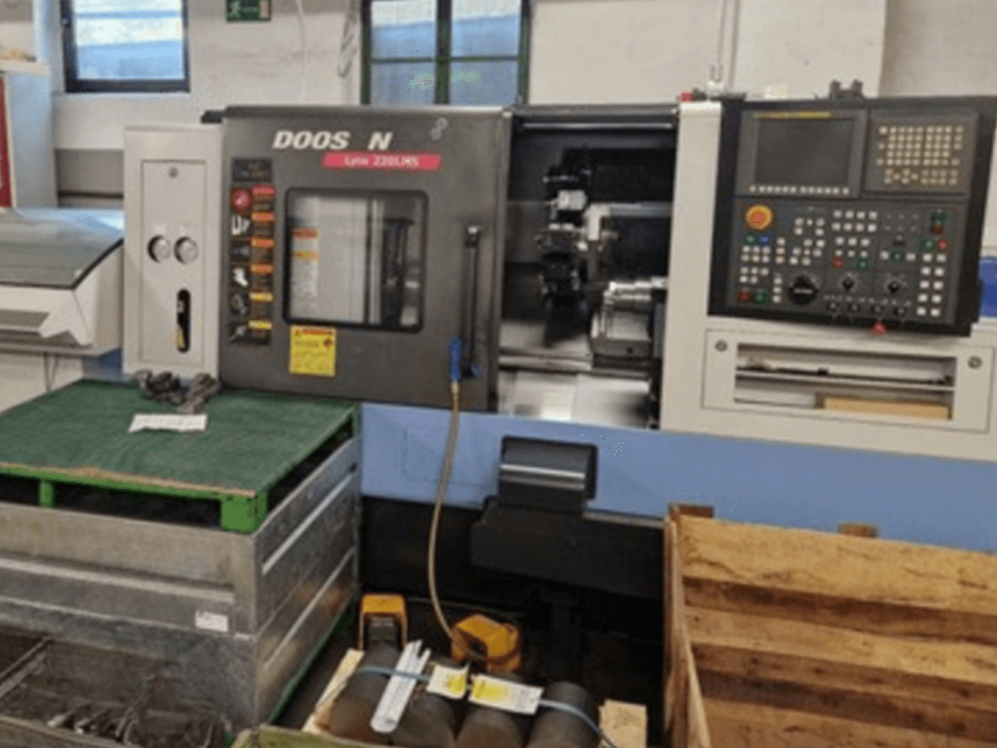 Horizontální soustruh DOOSAN Lyax 220 LMS v čelním pohledu, ukazuje ovládací panel, nástroje a pracovní prostor.