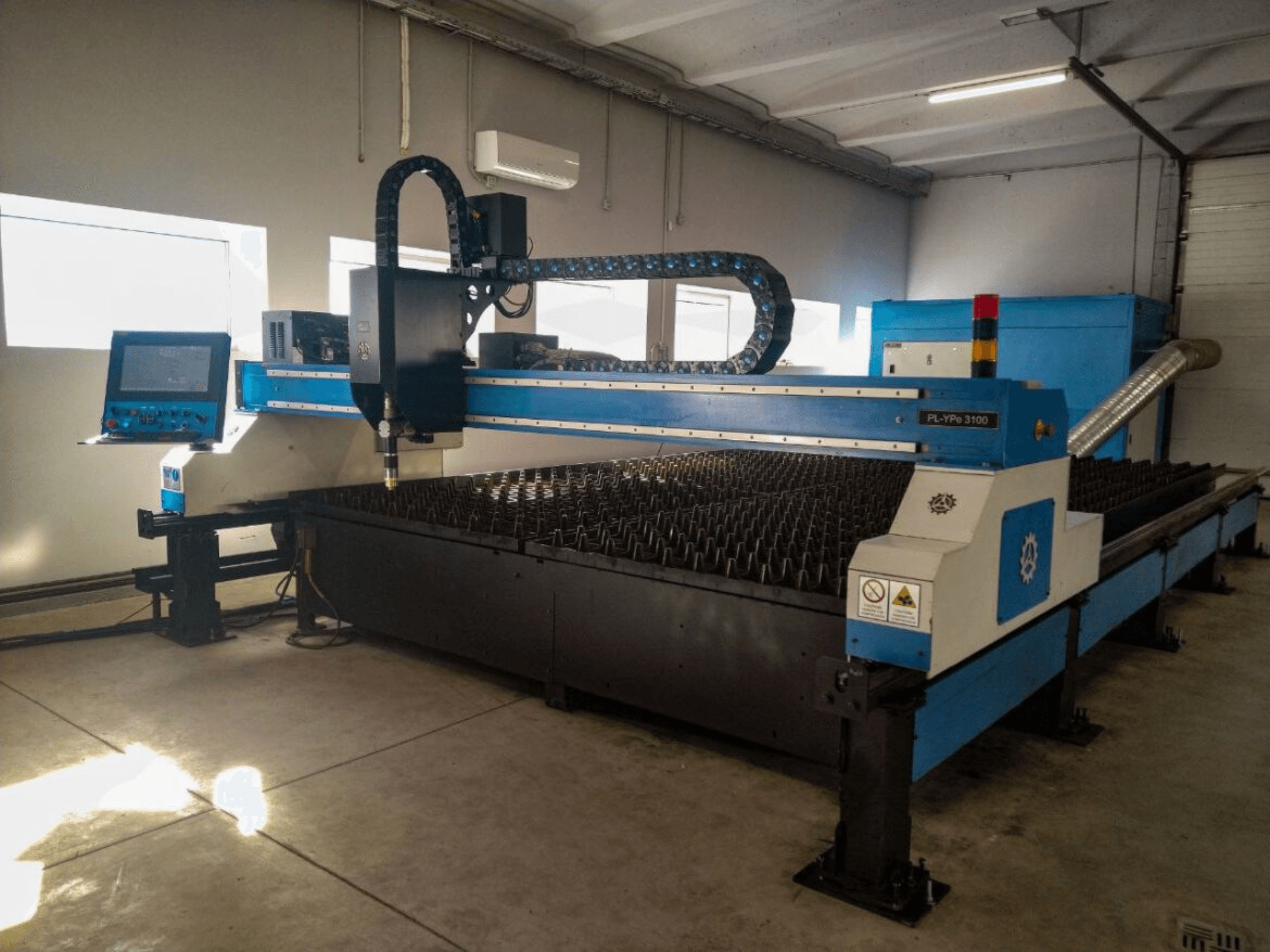 CNC řezací stroj PL-YP© 3100 s displejem, pohled zepředu, s kovovým řezacím ložem a přesným systémem vedení trysek.