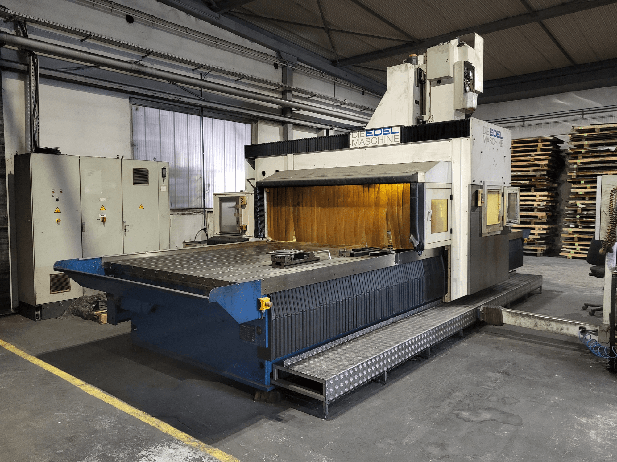 Portálová frézka EDEL Koordimatic XL 4020, pohled zepředu, ukazuje velký pracovní stůl a řídicí jednotku v průmyslovém prostředí.